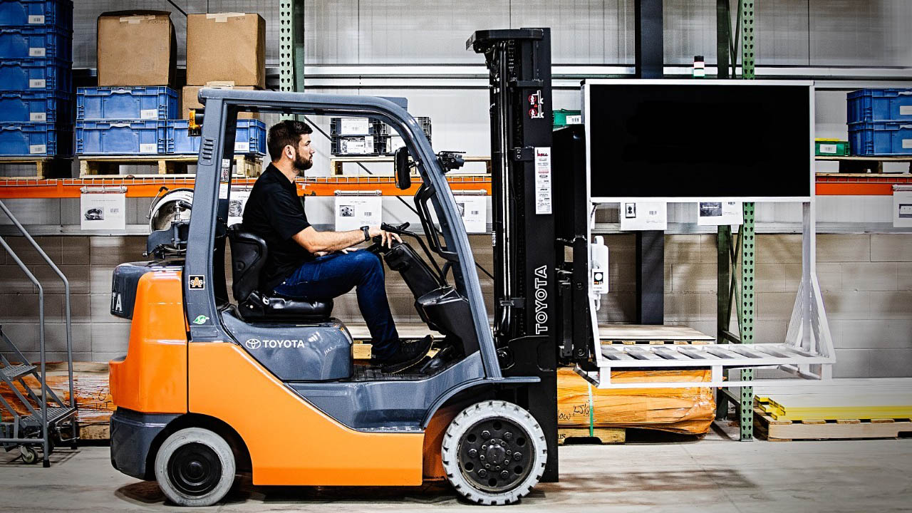 A forklift operator does an inventory count in a warehouse using a Zebra mobile pallet RFID reader