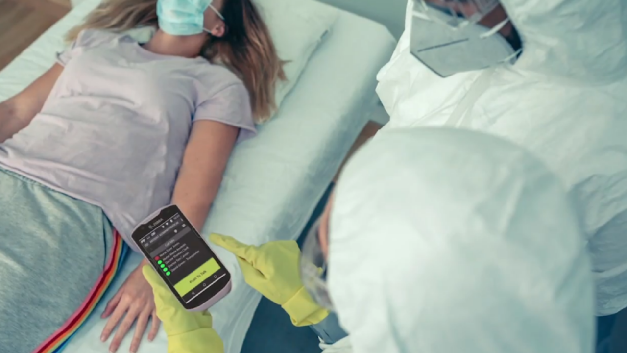 A nurses uses a clinical smartphone to retrieve a COVID-19 patient's medical record