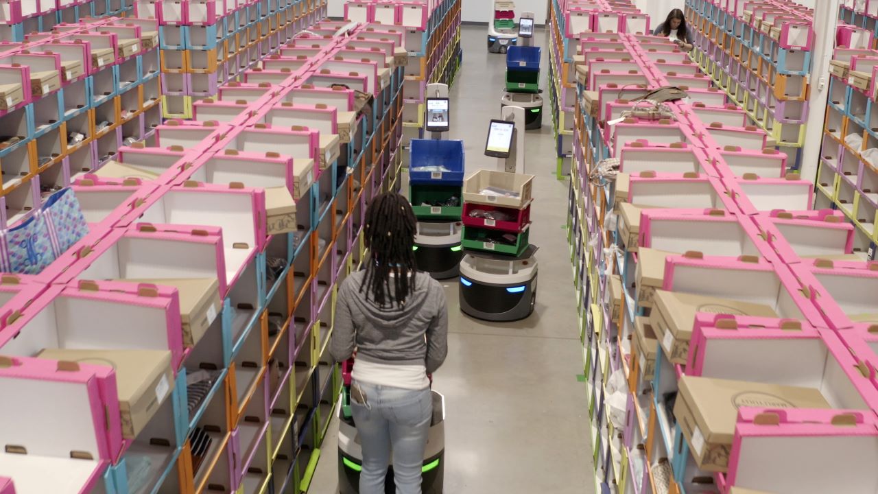 A warehouse worker picks items alongside Locus Robotics' robots.