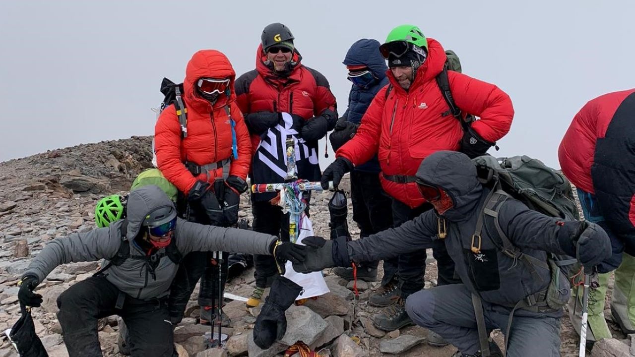 Simon Wallis, Mark Thomson and Jason Harvey celebrate with their guides and teammates after successfully summiting Mount Aconcagua
