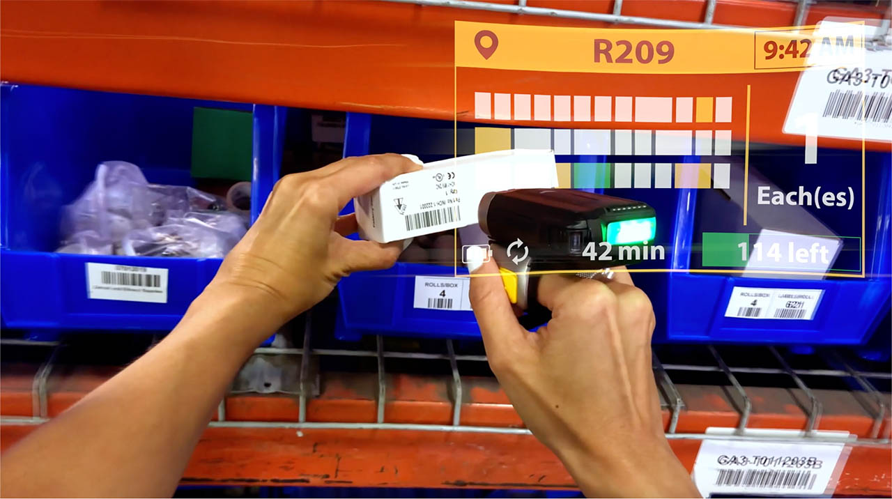 A warehouse worker uses a ring scanner and FulfillmentEdge to pick an item.