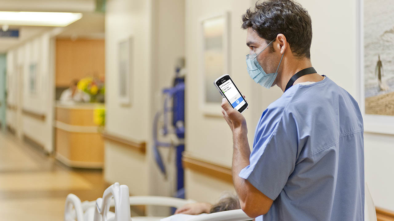 A porter reports a patient's location using a push-to-talk app on his clinical smartphone