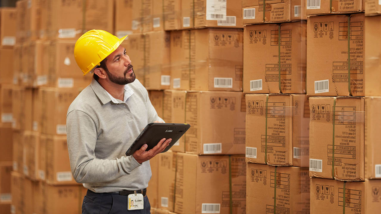 A warehouse worker uses a Zebra ET8x rugged tablet when inspecting inventory
