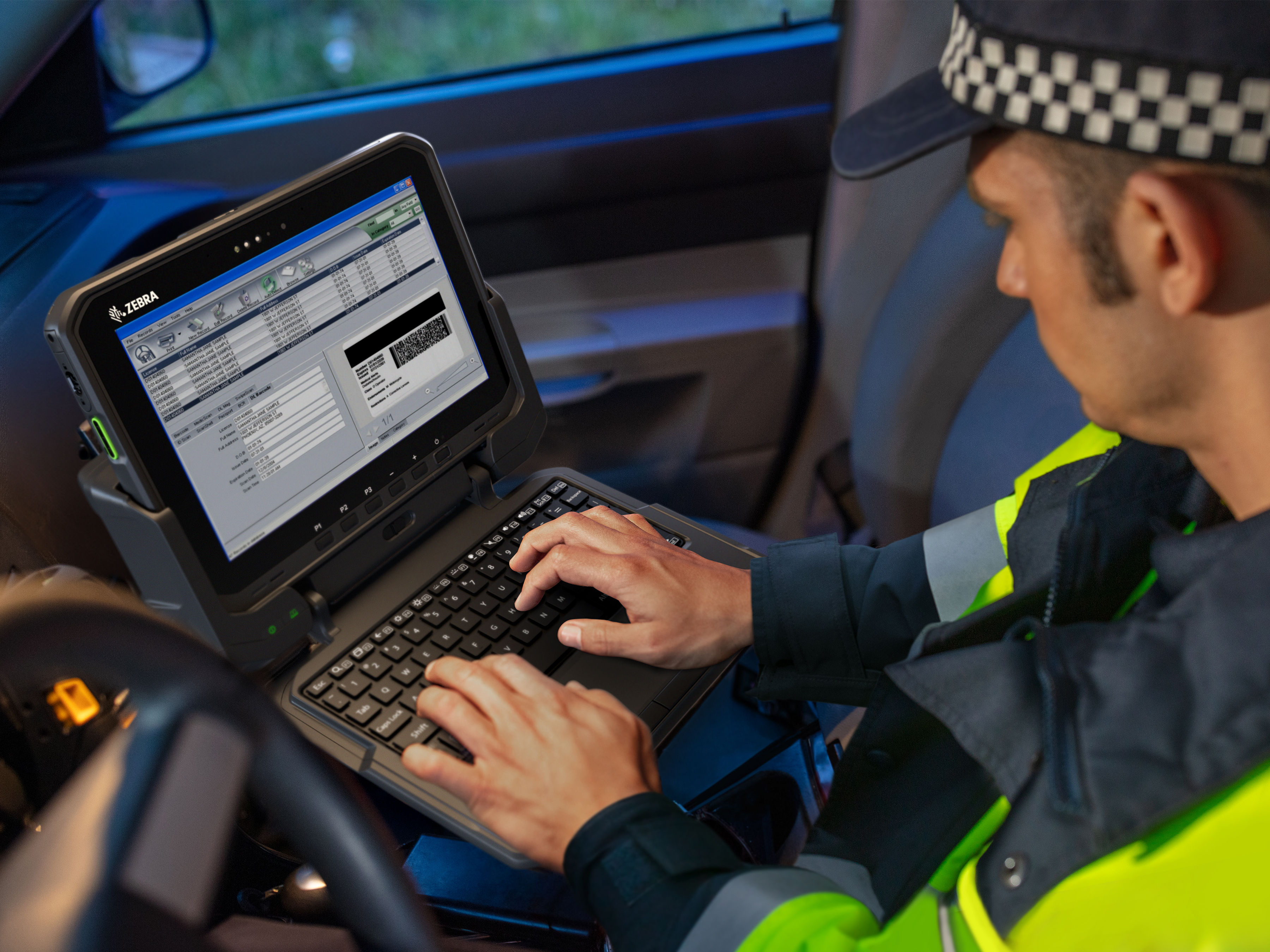 Police officer typing on keyboard in car