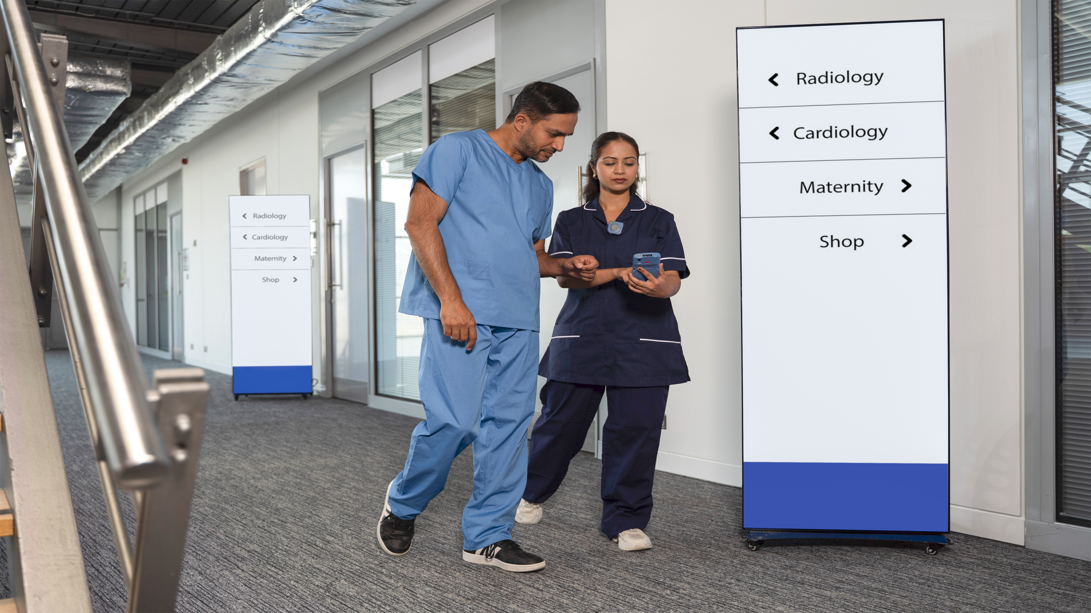 Digital displays in healthcare environment, operated and managed by ZEC500, a healthcare worker wearing WS101-H and holding HC50