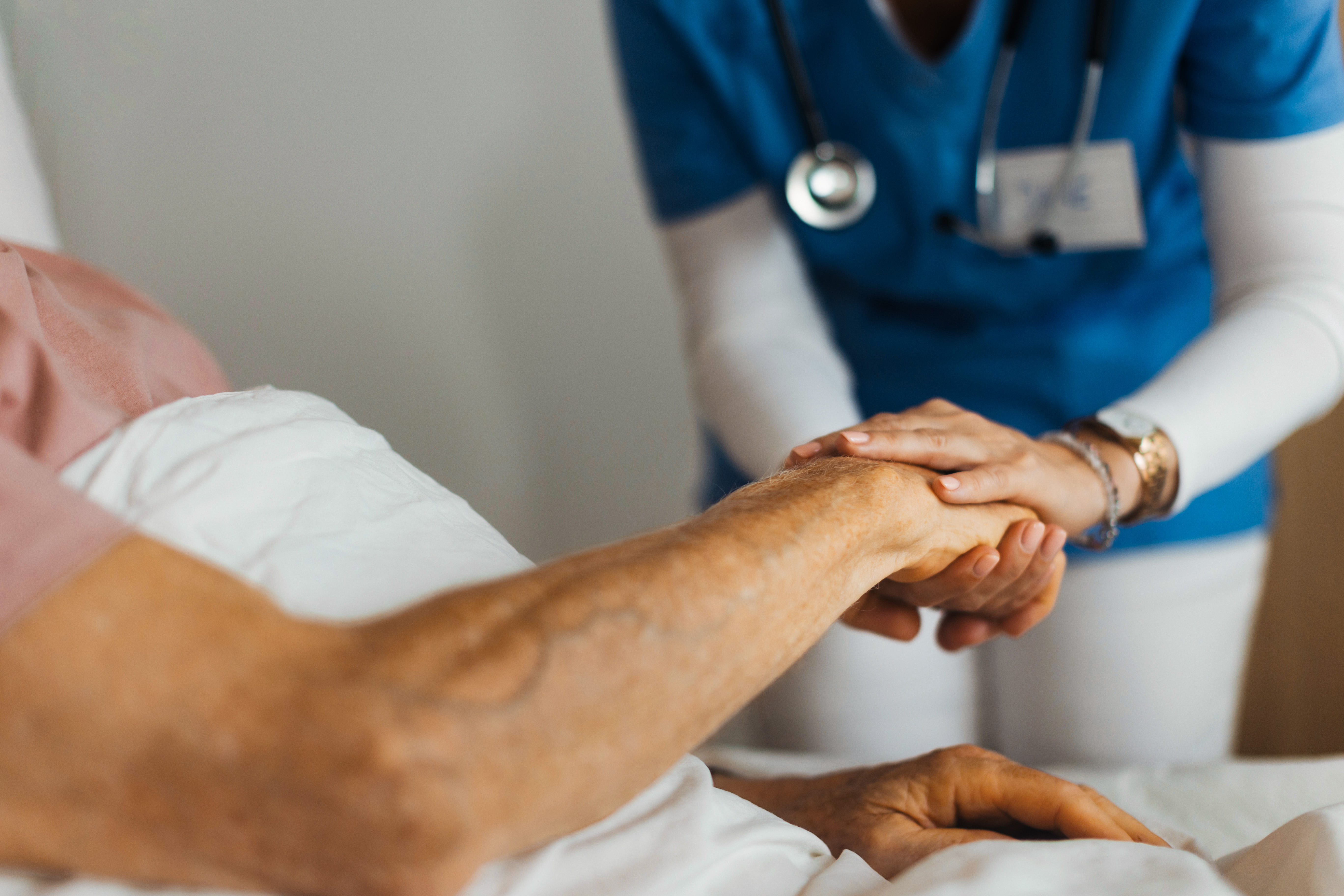 Medical worker holding the hand of a patient. 