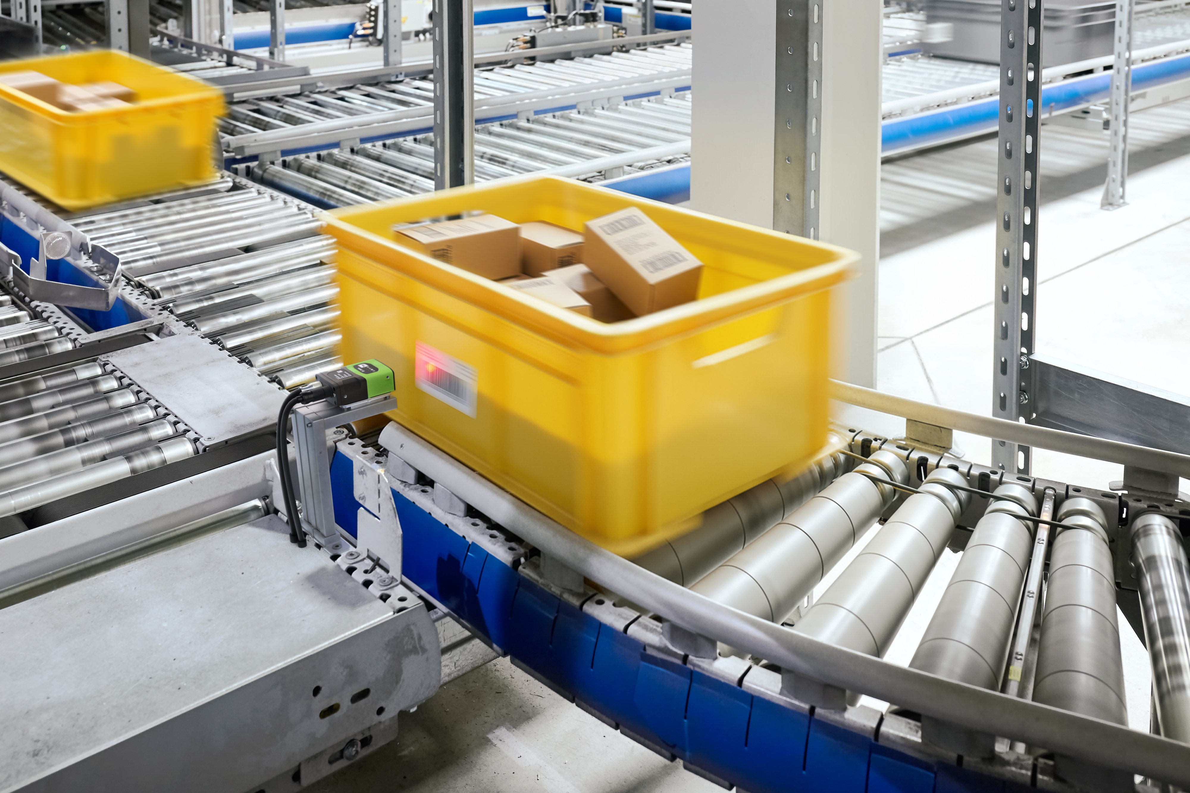 Totes on a conveyor are scanned by the FS20 Fixed Industrial Scanner for identification before being routed. This image was generated with the assistance of AI tools and may not depict real people, places, or events. 