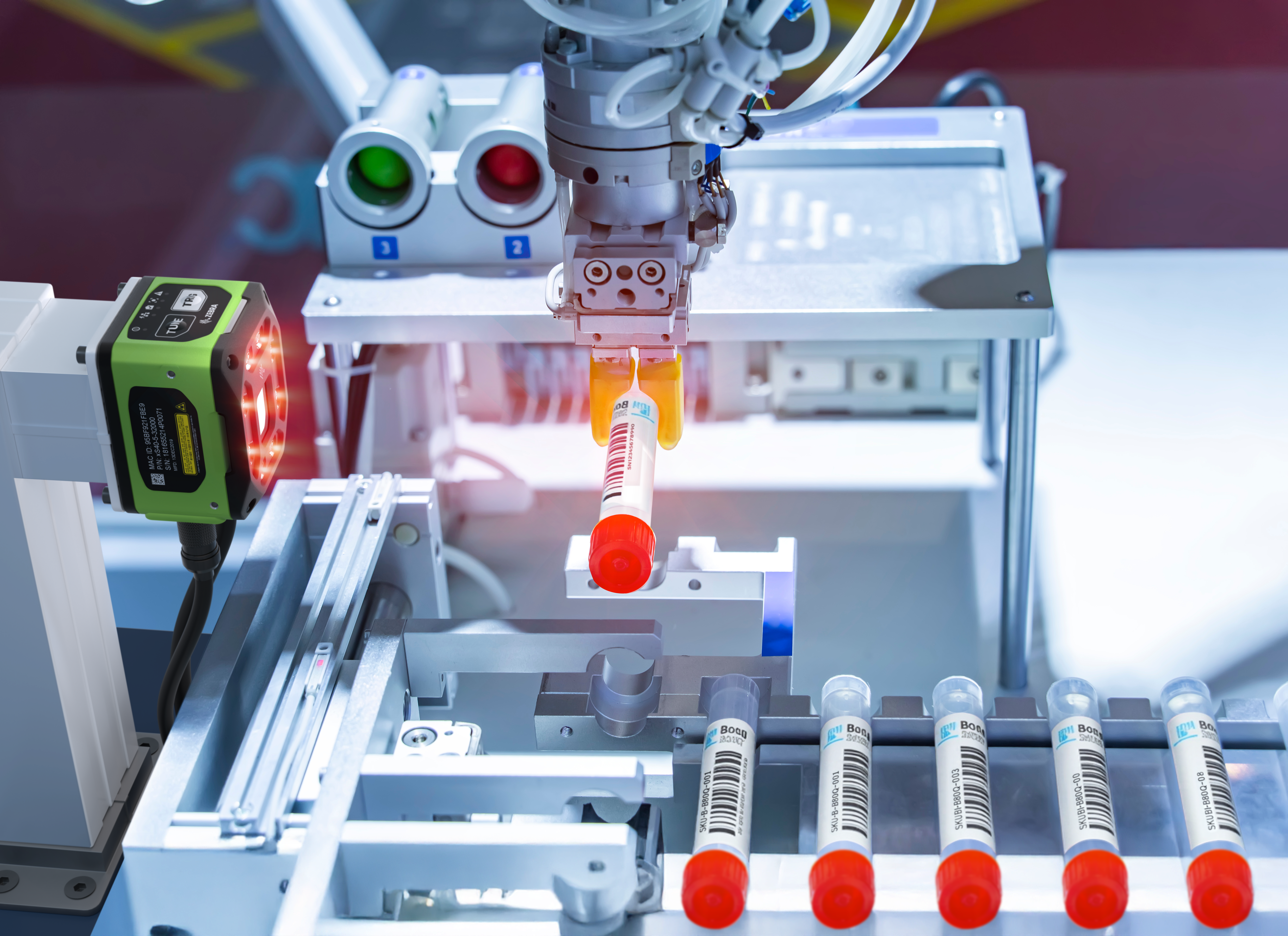 A pharmaceutical vial is lifted by a robotic arm and being read by the FS42 Fixed Industrial Scanner. This image was generated with the assistance of AI tools and may not depict real people, places, or events.