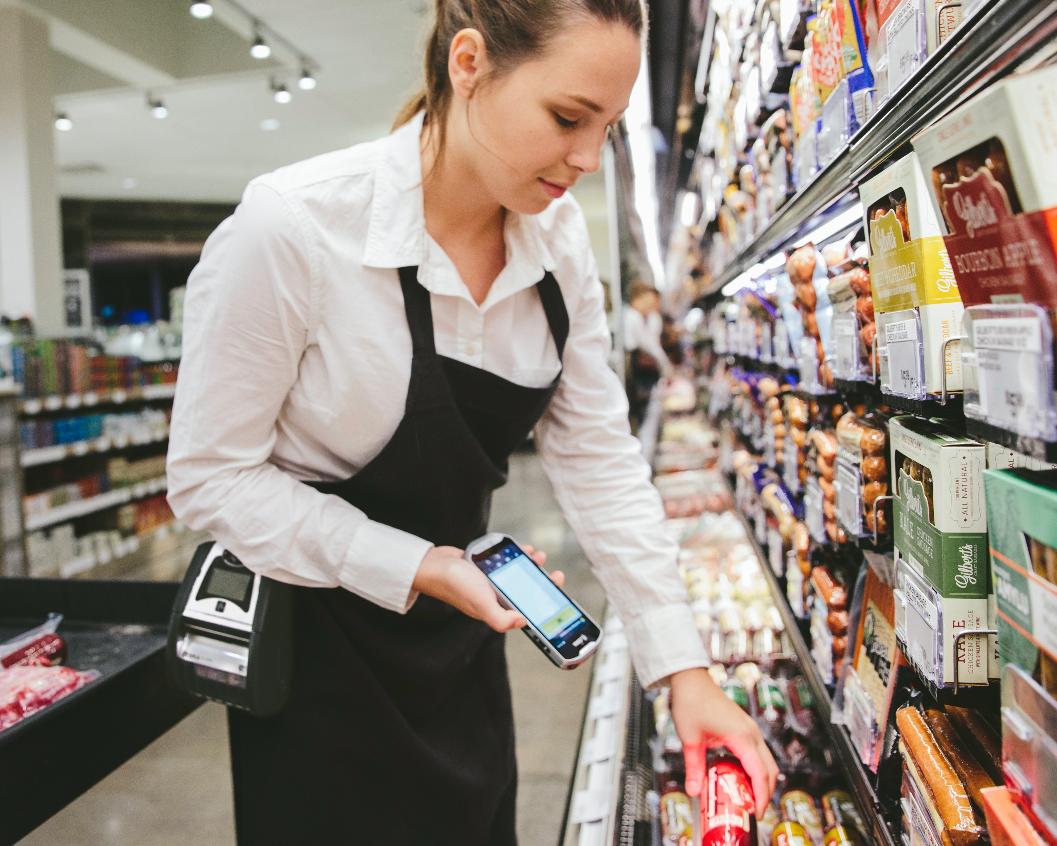 Grocery store worker price checks using Zebra handheld mobile computer scans