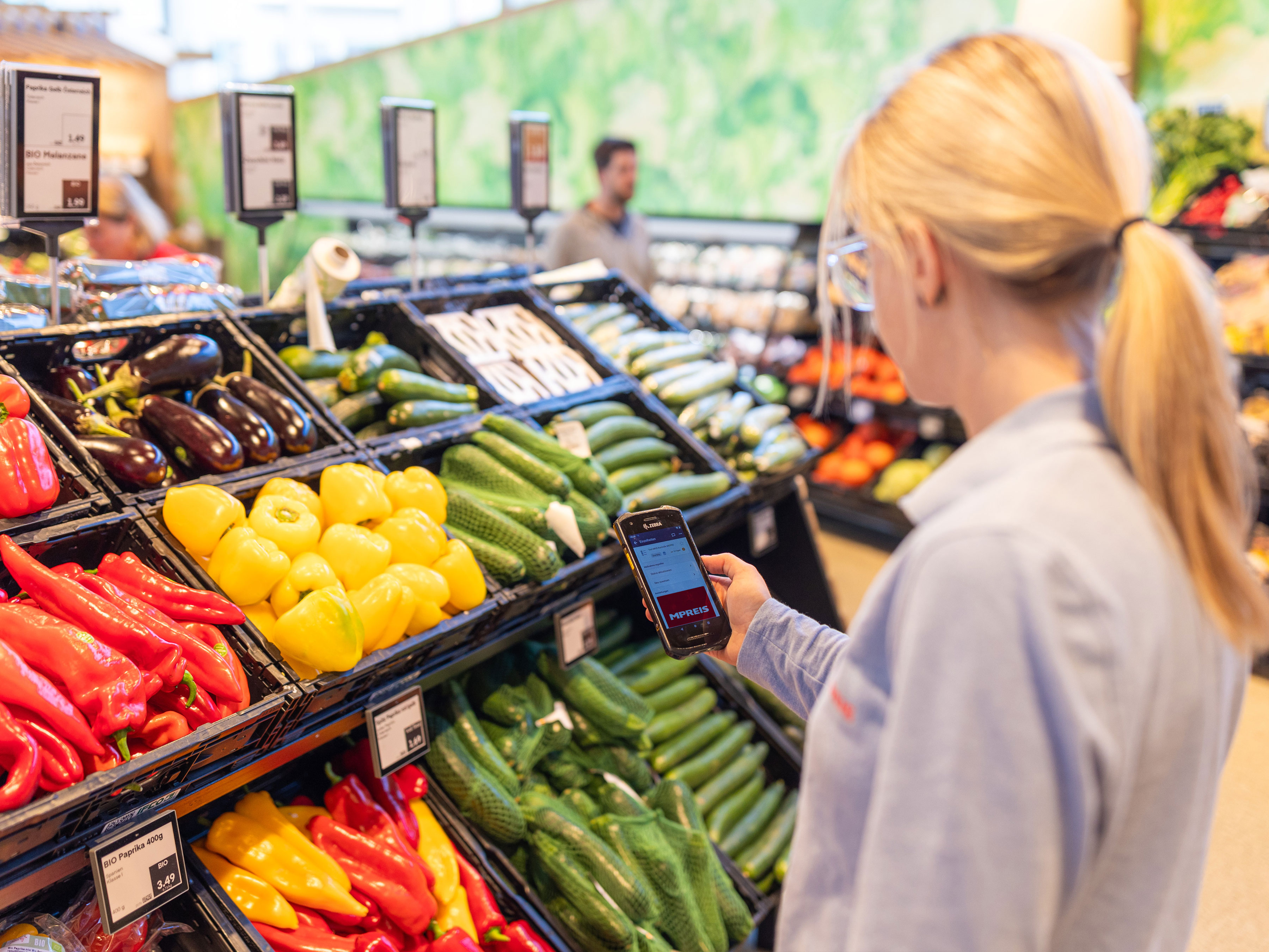 Employee at a grocery store with Zebra device