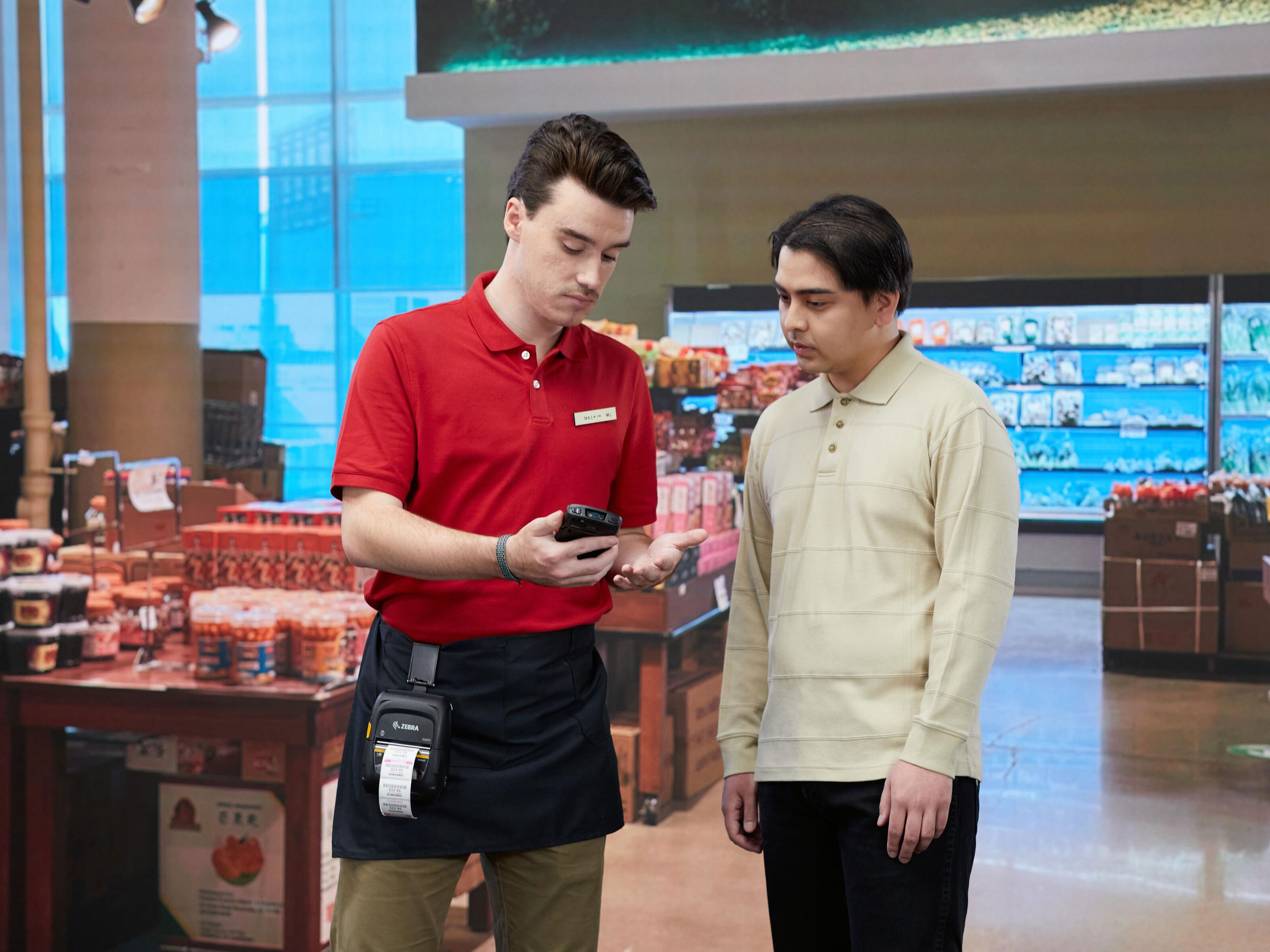 Employee and client at a grocery store with Zebra device