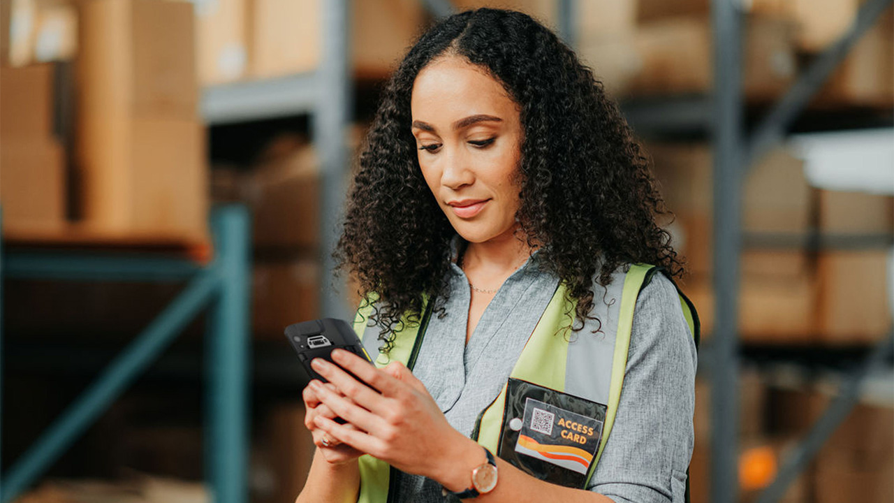 Warehouse worker using smartphone for inventory
