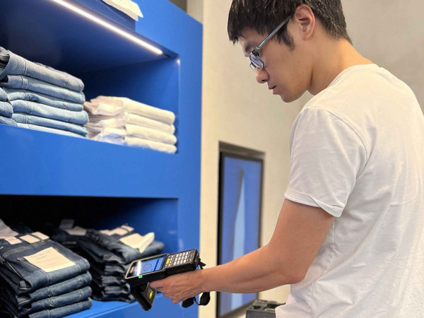 Retail employee using a handheld barcode scanner to manage store inventory