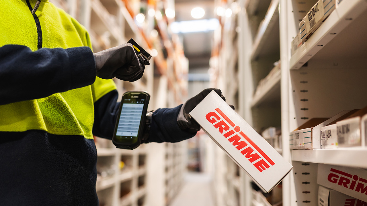 Warehouse worker scanning GRIMME product box with Zebra scanner