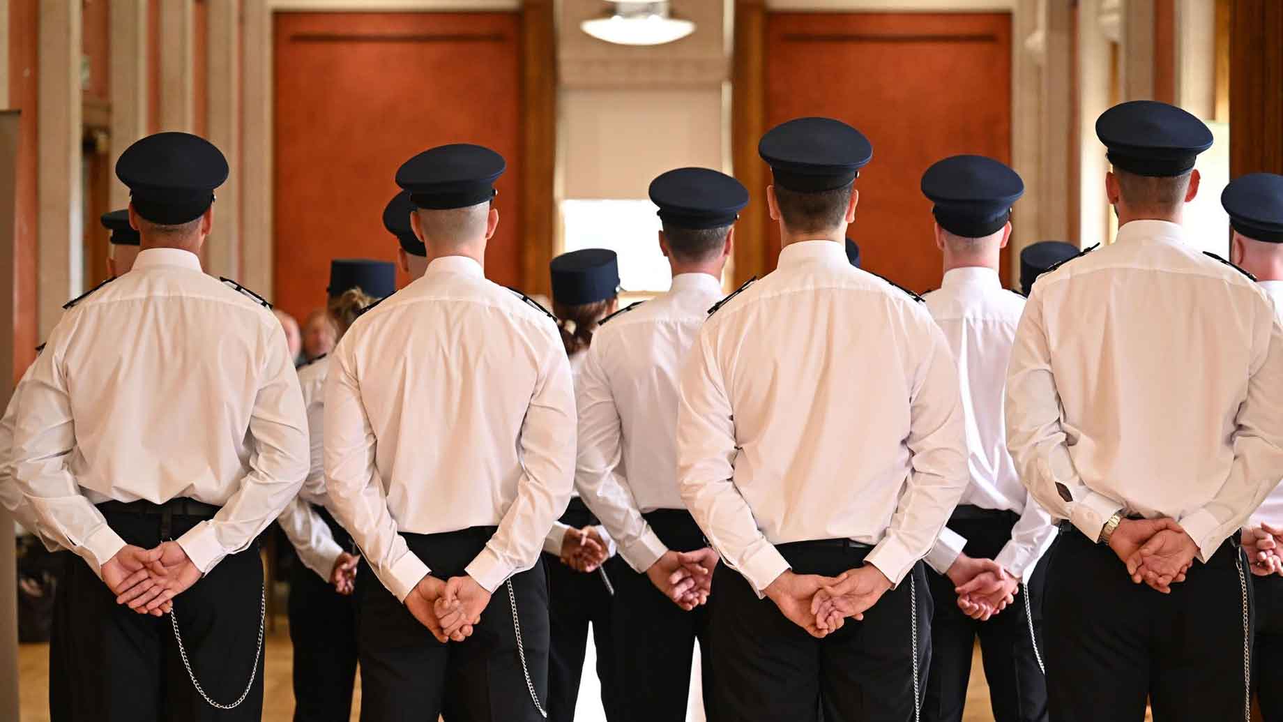 Policemen facing away with hands on the back