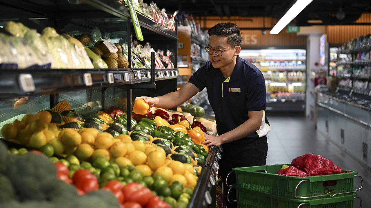 Grocery worker arranging fresh produce display