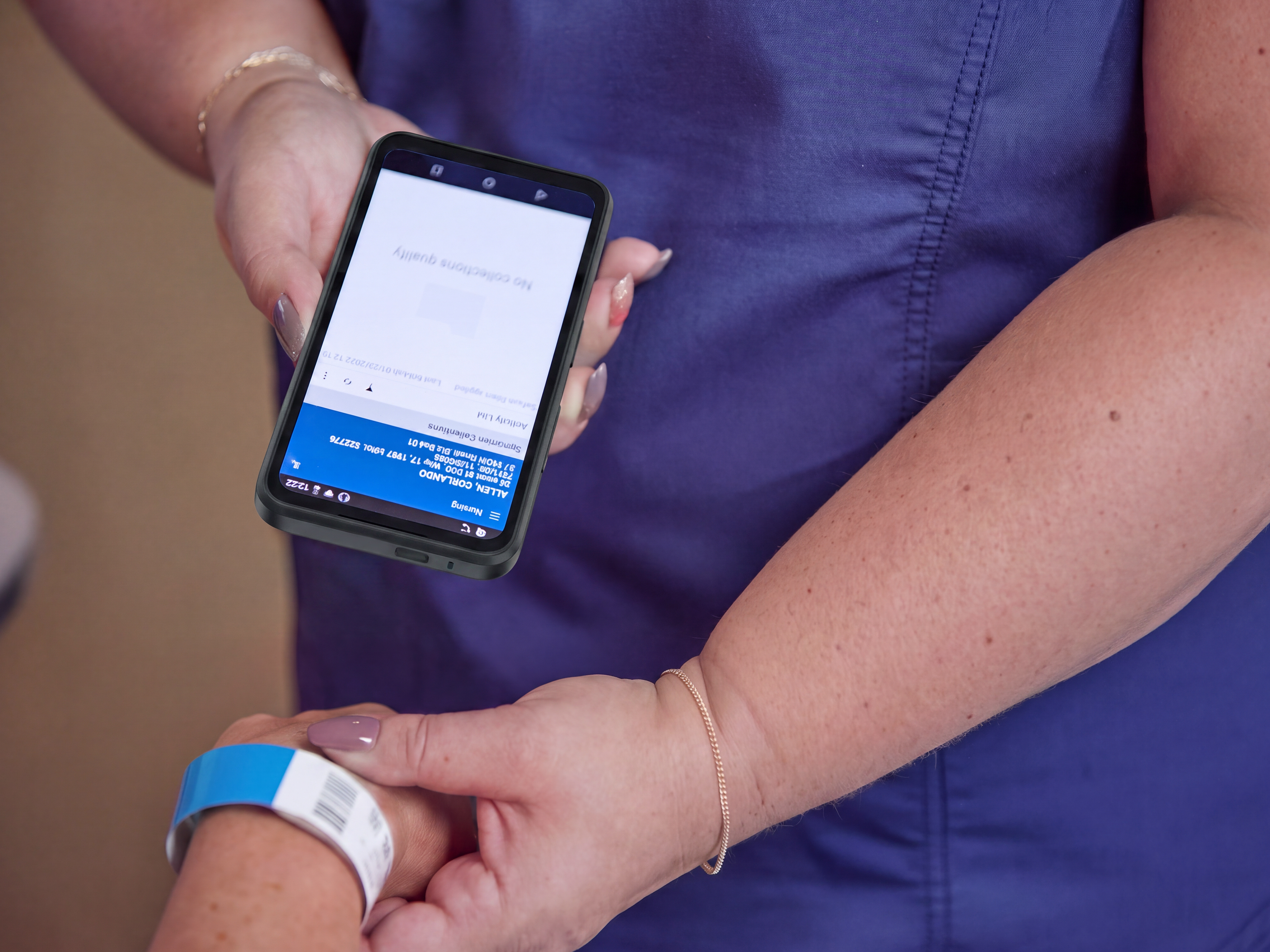 A healthcare worker uses a Zebra EM45 mobile computer to scan a patient's wristband for clinical data capture and verification.
