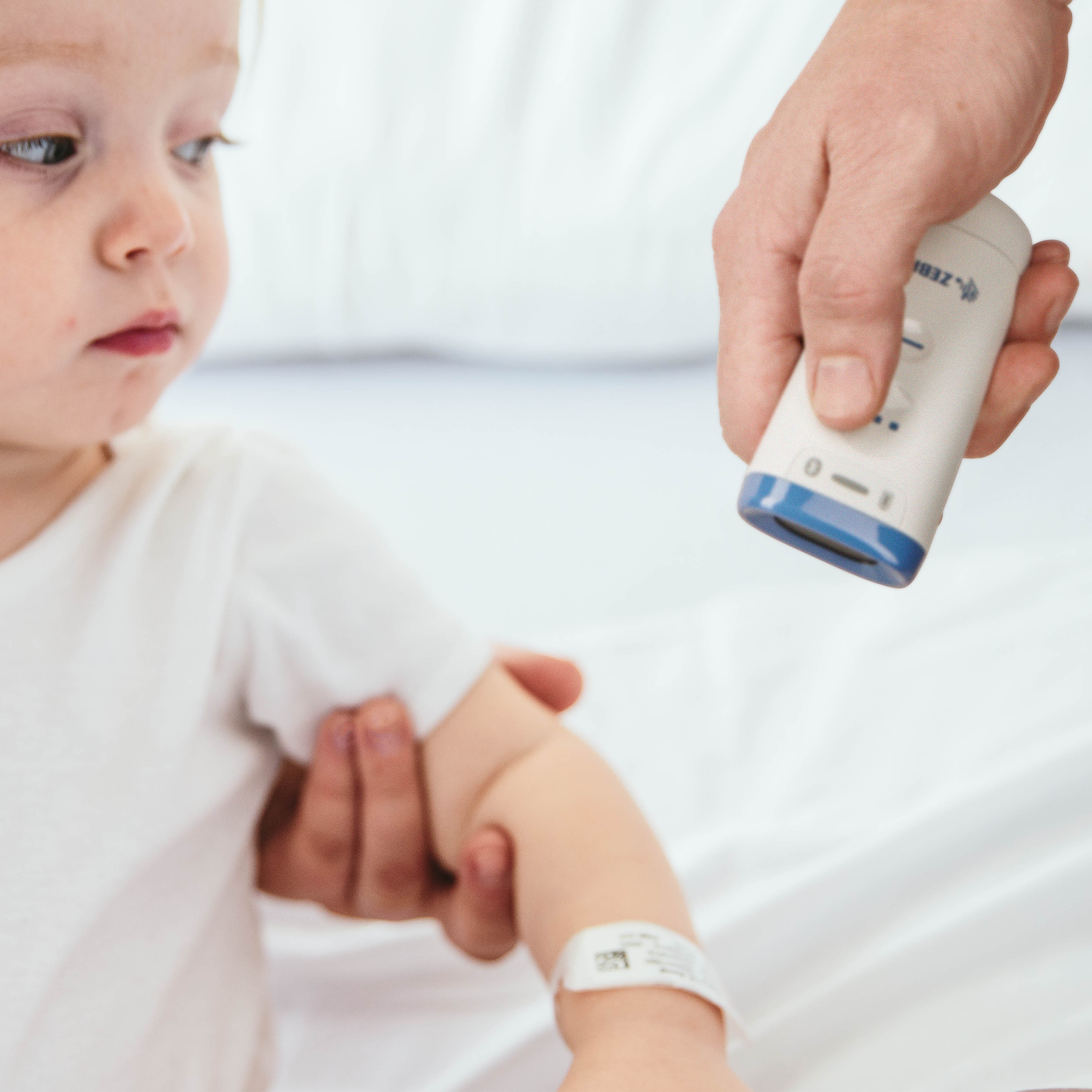 A healthcare professional using a Zebra CS60-HC companion scanner for pediatric patient bedside identification, ensuring patient safety and accurate medical care delivery.