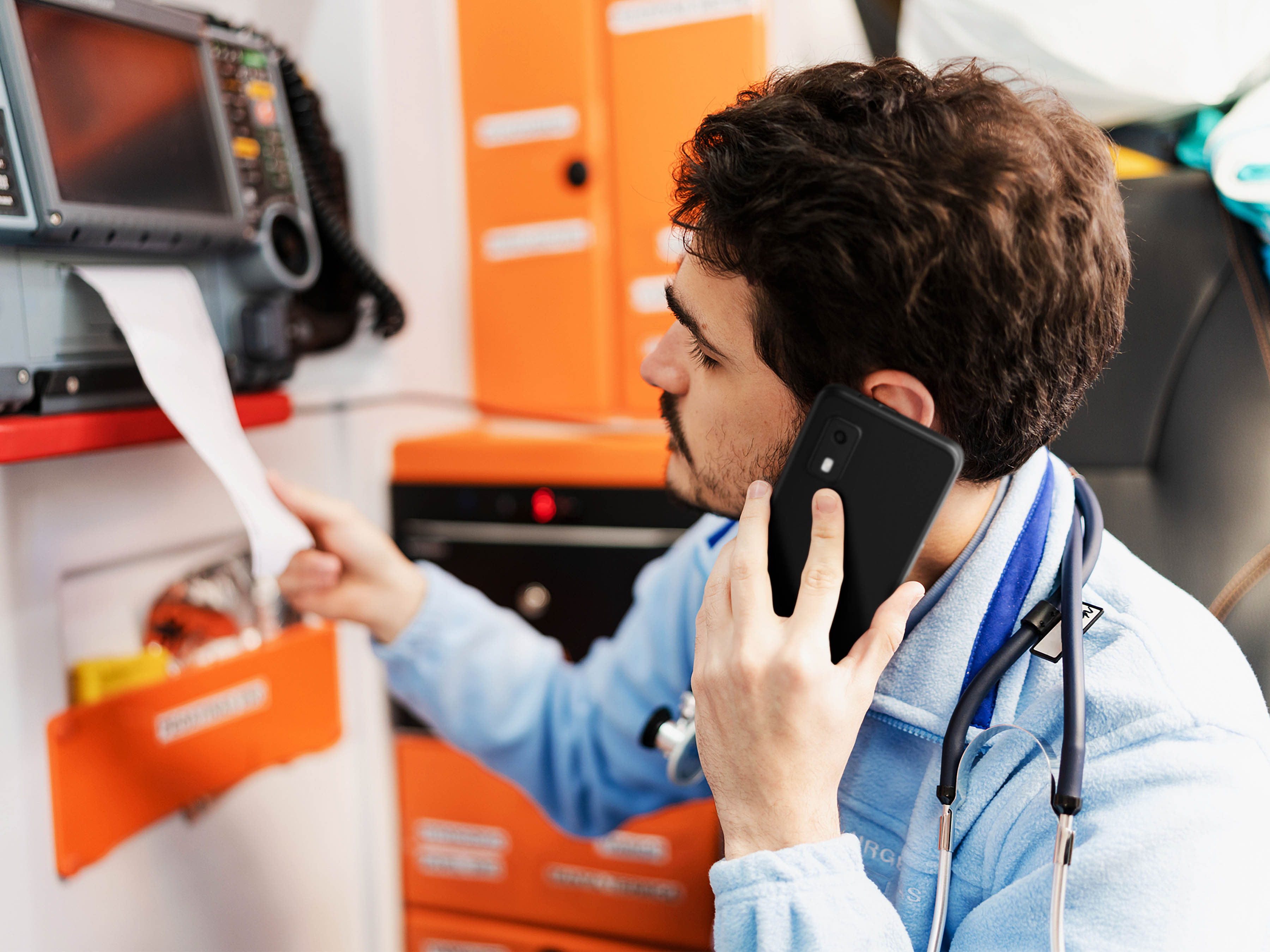 A healthcare professional utilizing the Zebra EM45 Enterprise Mobile computer in a clinical hospital setting for patient bedside identification and workflow tracking, showing how its sleek, lightweight, yet rugged smartphone form factor aids clinicians on the move.