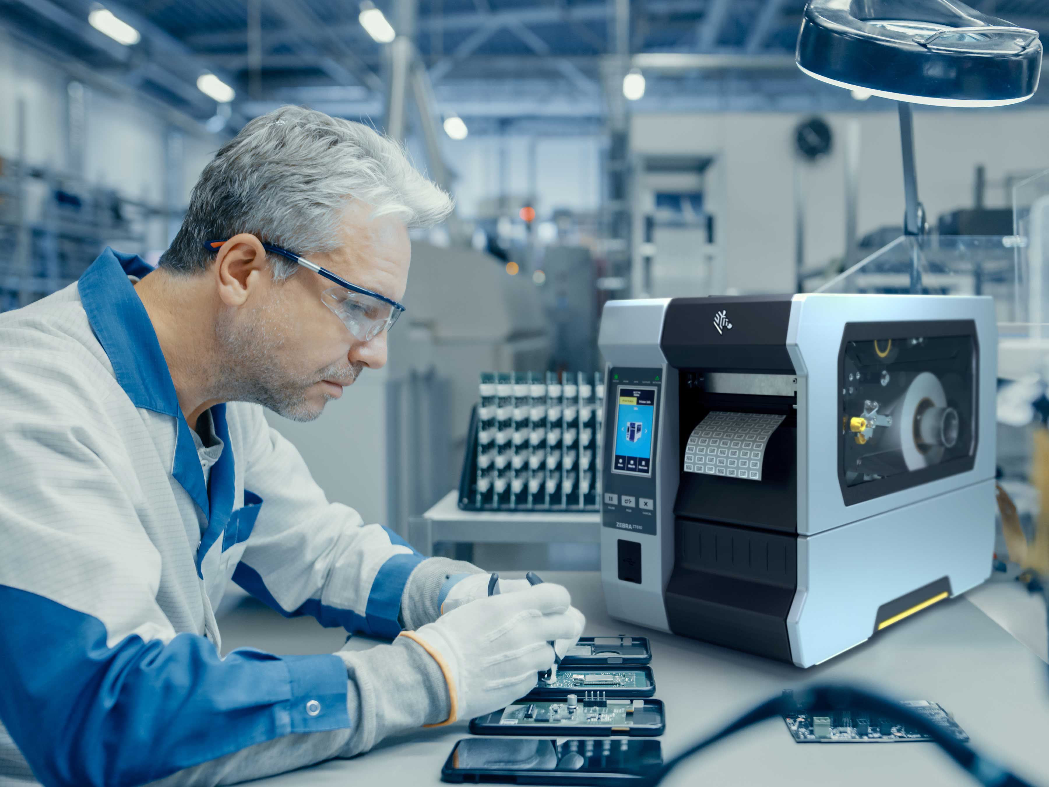 A technician in a manufacturing facility uses a Zebra ZT610 industrial printer to produce high-definition labels for intricate electronic components during the assembly process.
