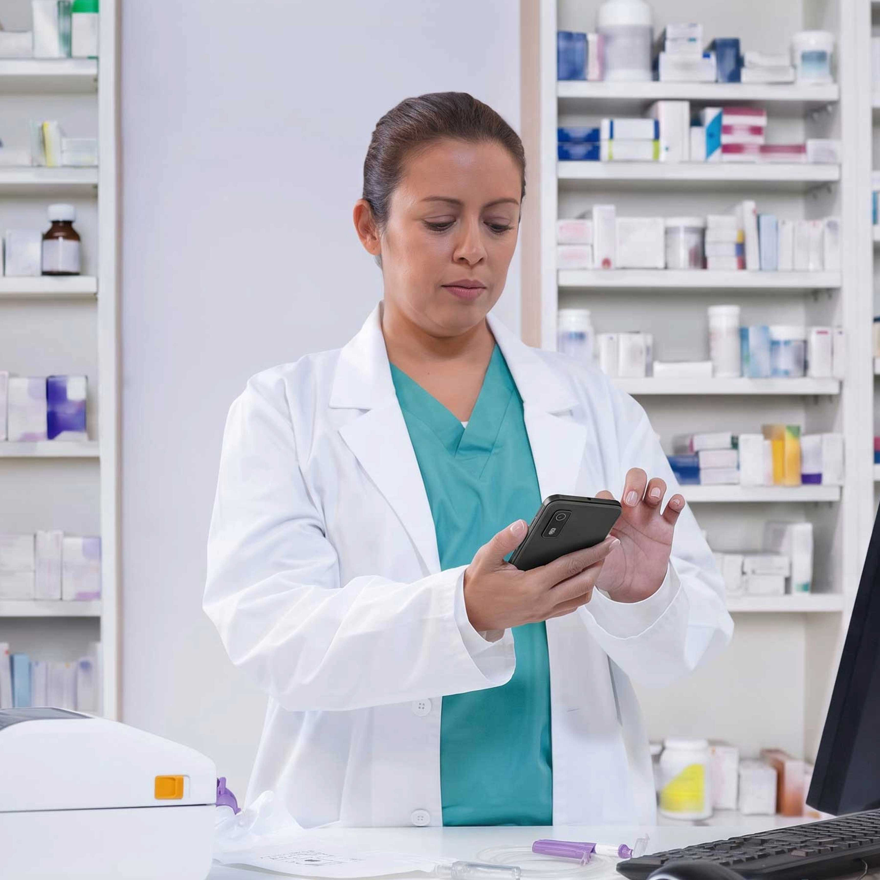 A pharmacist uses a Zebra EM45 mobile computer to manage data and inventory in a retail pharmacy setting.