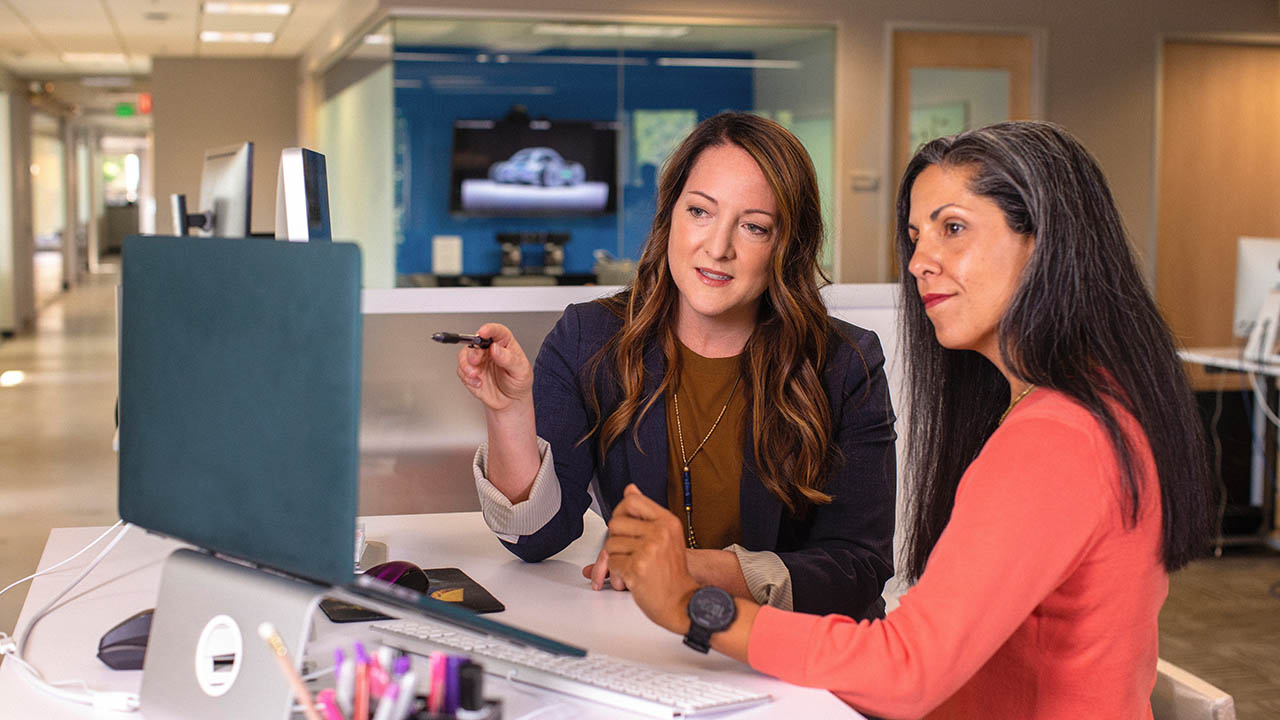 Two women sit at a computer