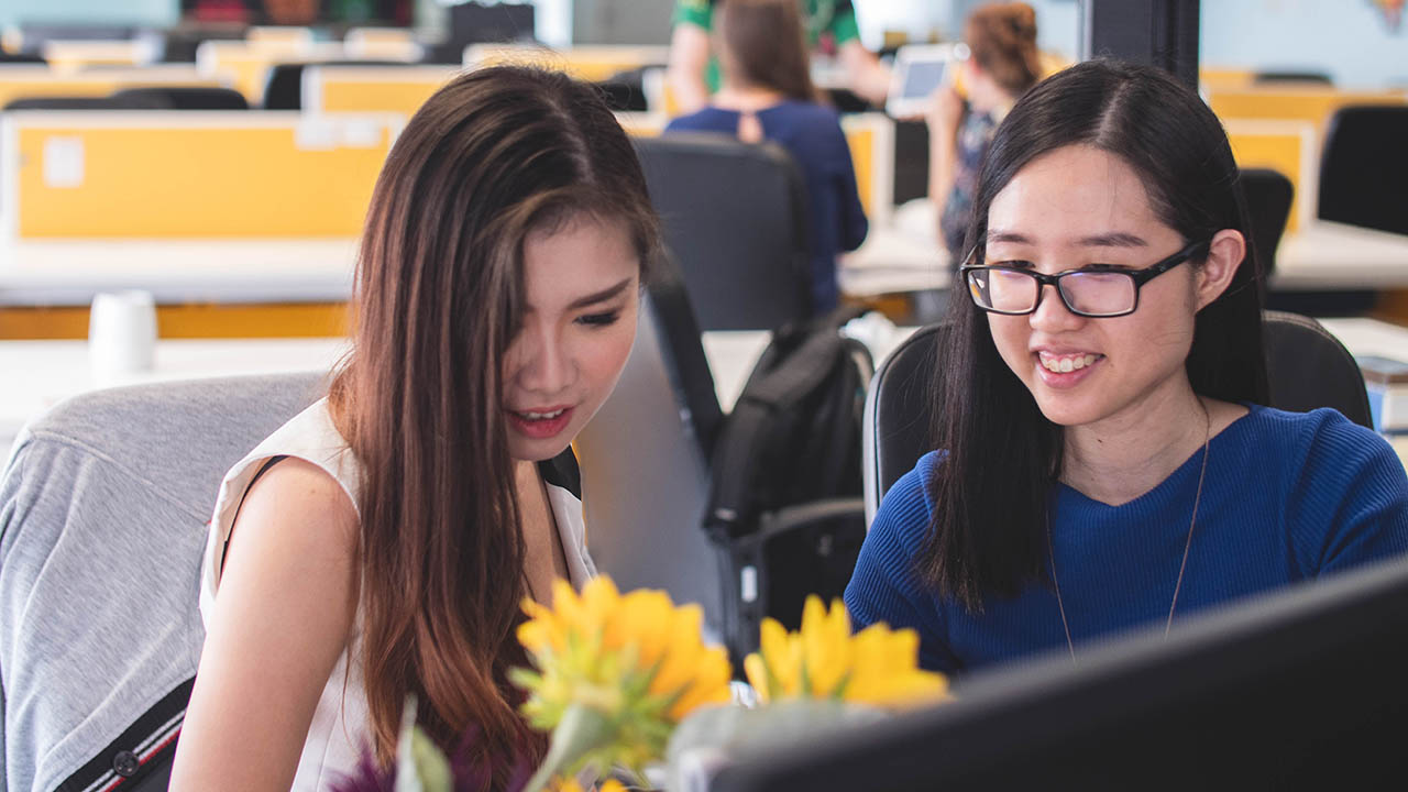 Two women look at a computer