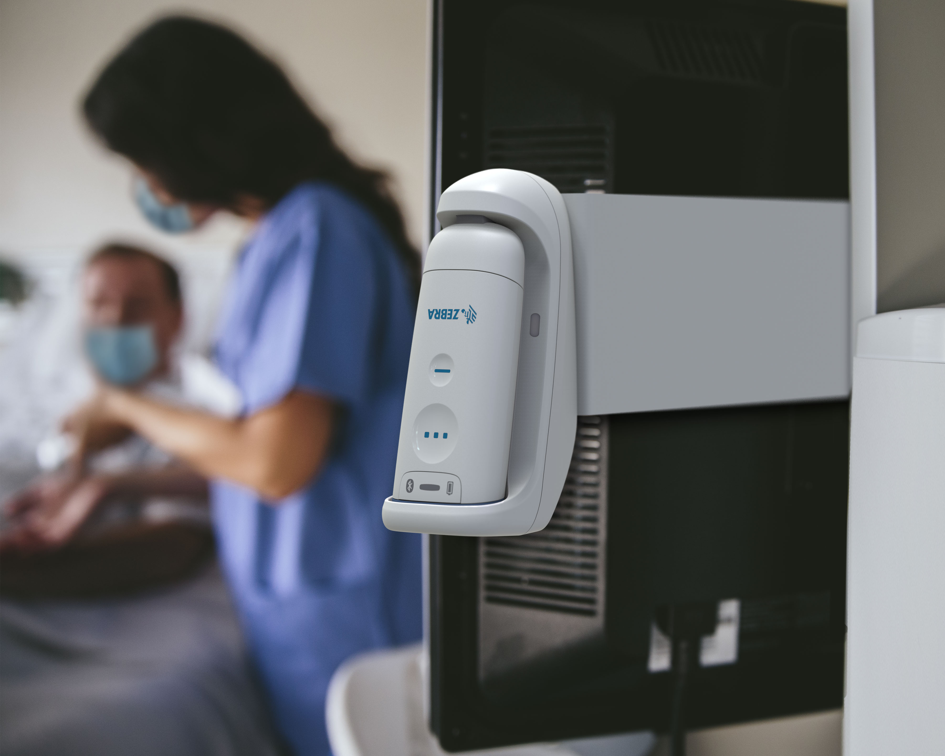 Zebra CS60 barcode scanner for healthcare is resting behind a monitor in a hospital