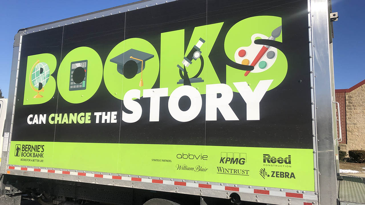The side of a Bernie's Book Bank truck says "Books Can Change the Story"