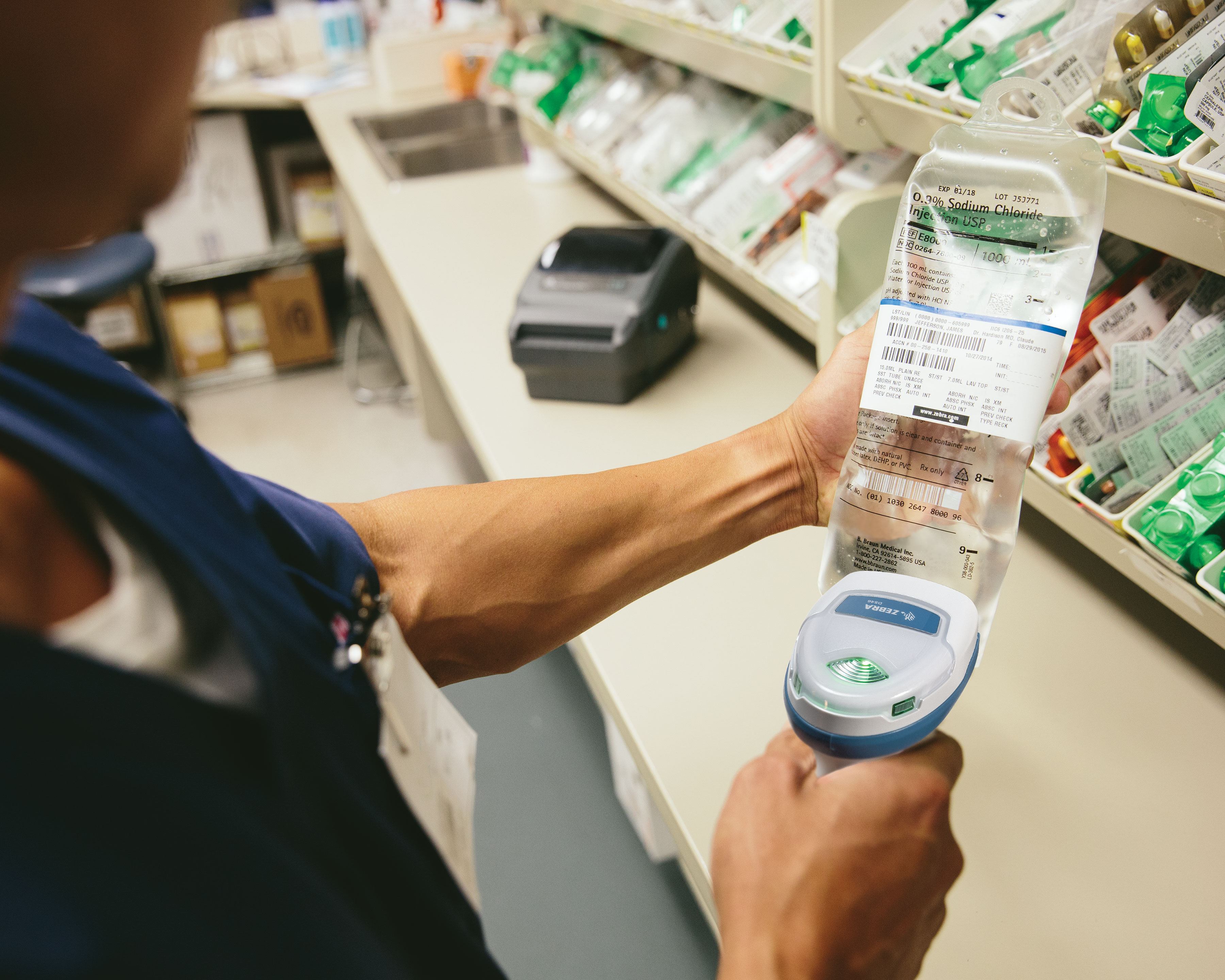Healthcare worker uses Zebra DS4600 handheld scanner to scan the label of an IV fluid solution bag