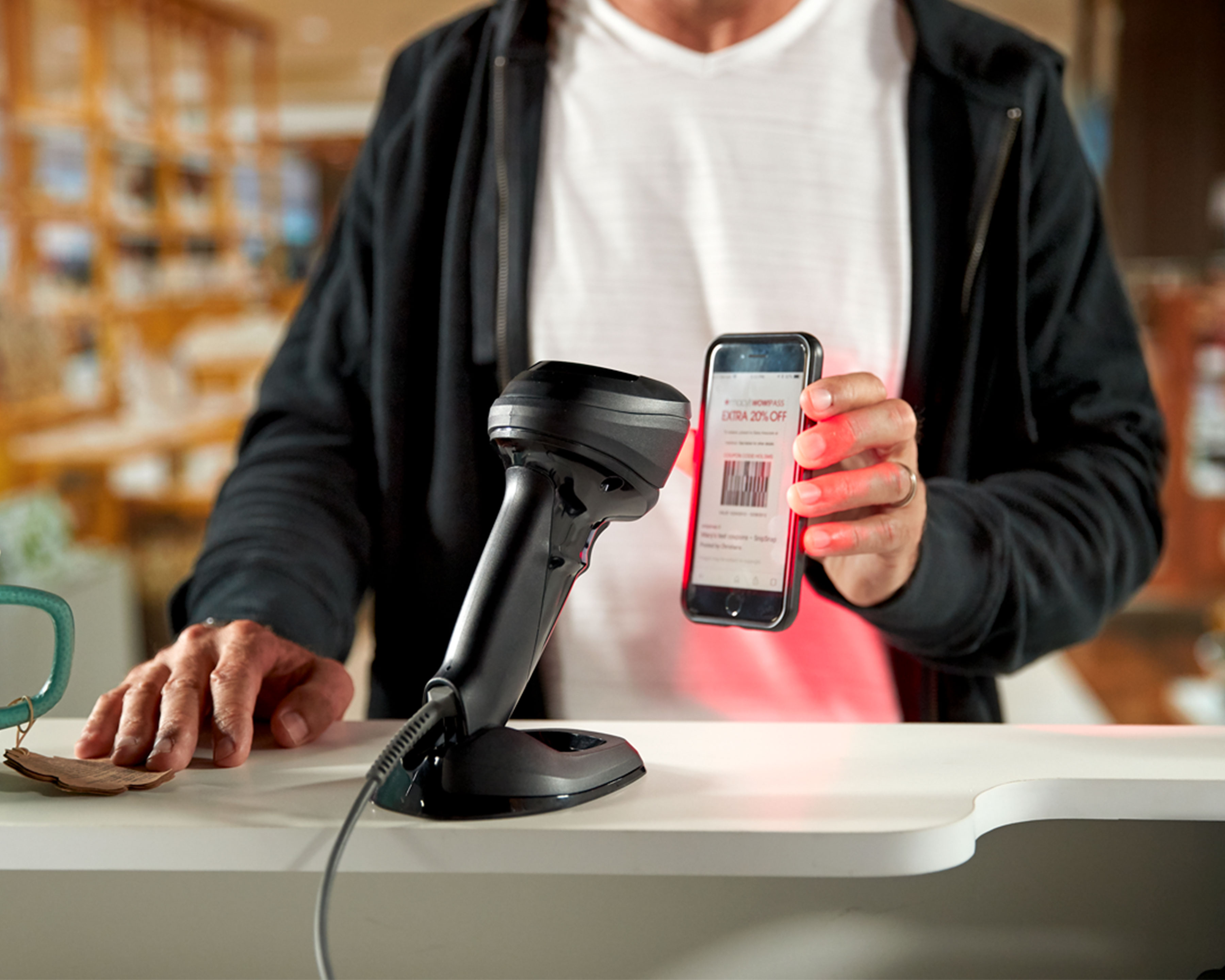 Customer uses hands free Zebra DS9900 barcode scanner to scan barcode on phone