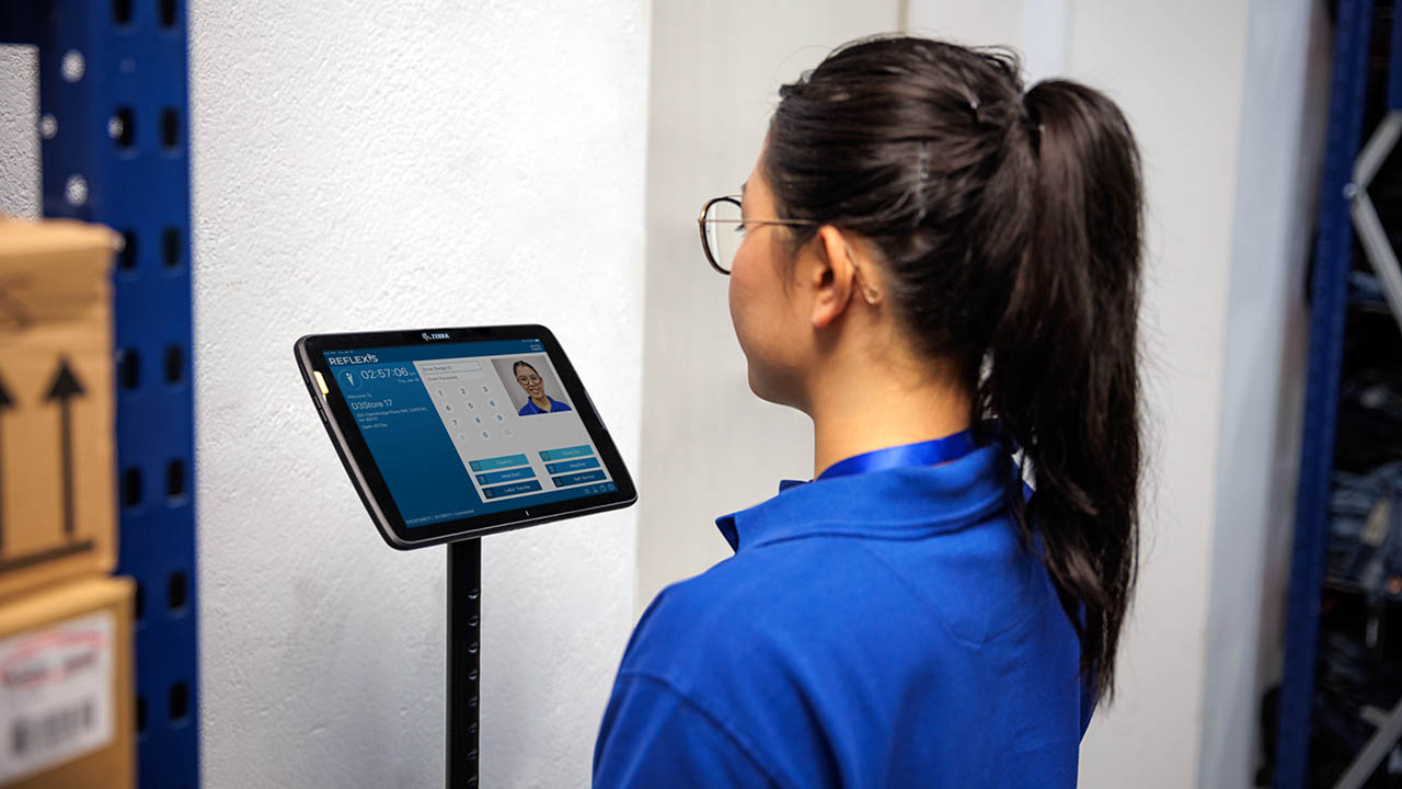 A retail associate clocks in using a Zebra tablet and Workcloud software