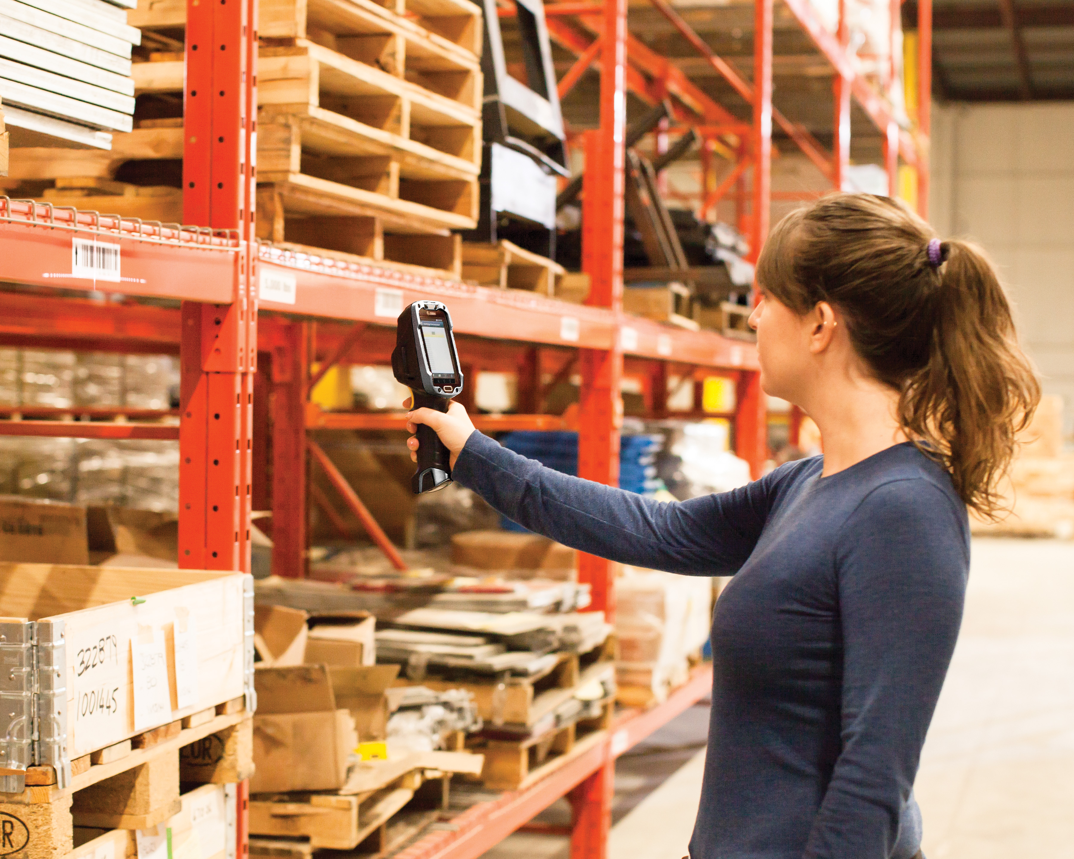 A woman scanning a barcode with a Zebra TC9300 handheld computer