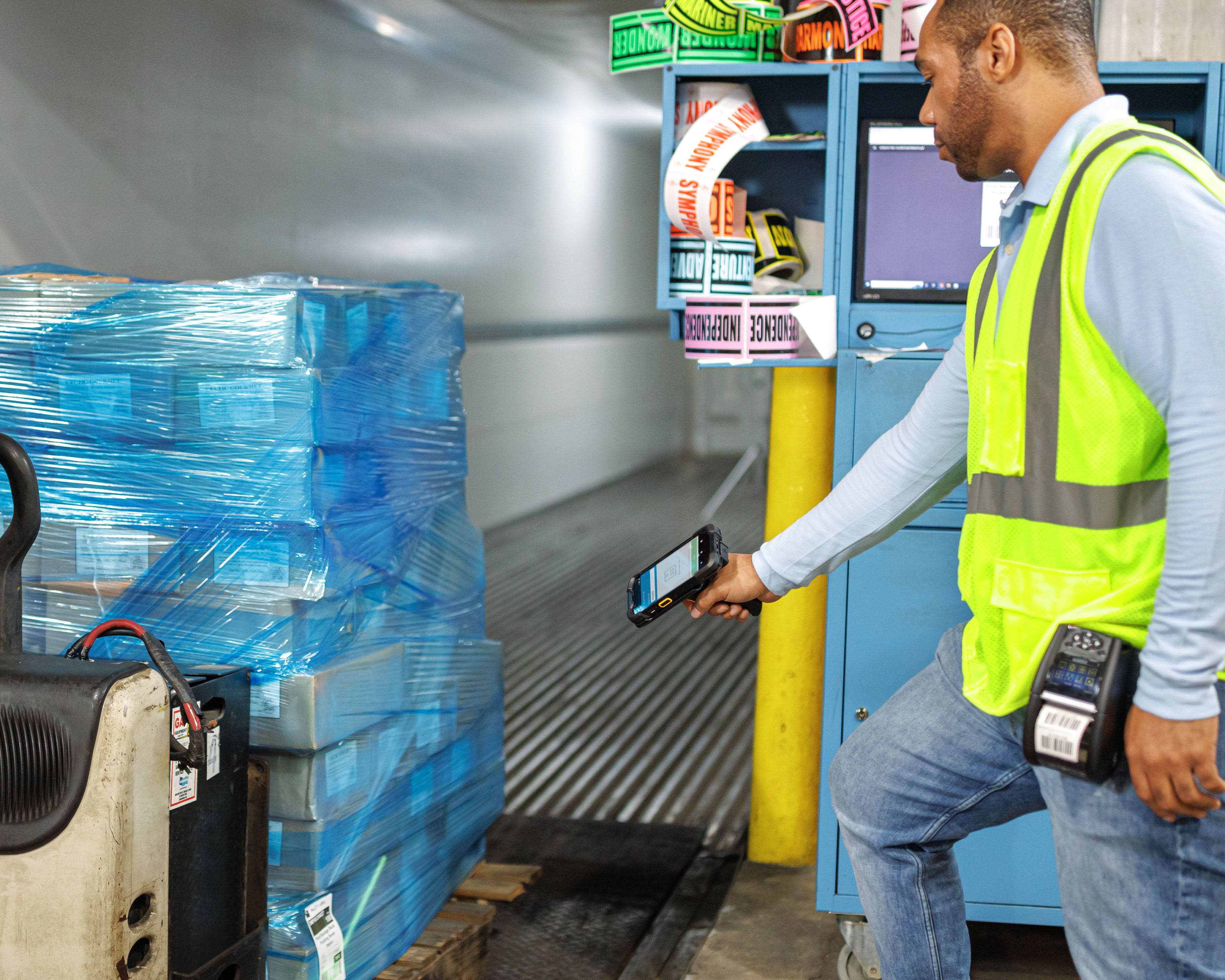 Warehouse worker using a Zebra TC78 handheld computer to scan a pallet