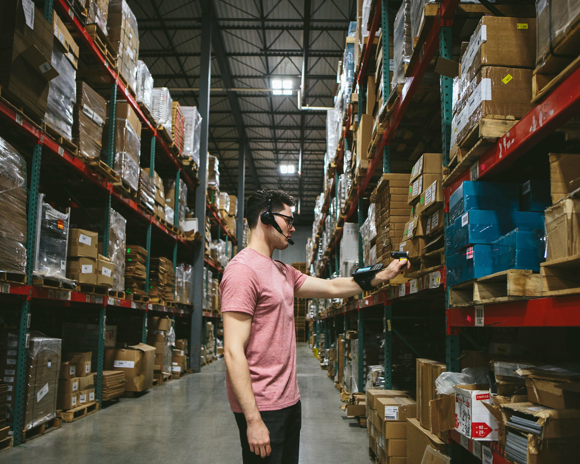 Associate scanning a carton with a Zebra ring scanner paired to a wrist-mounted WT6300 in a distribution center