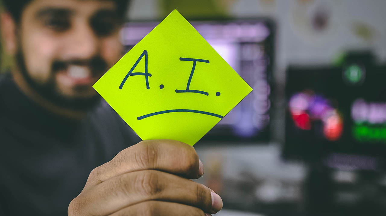 A man holding a sticky note that says AI