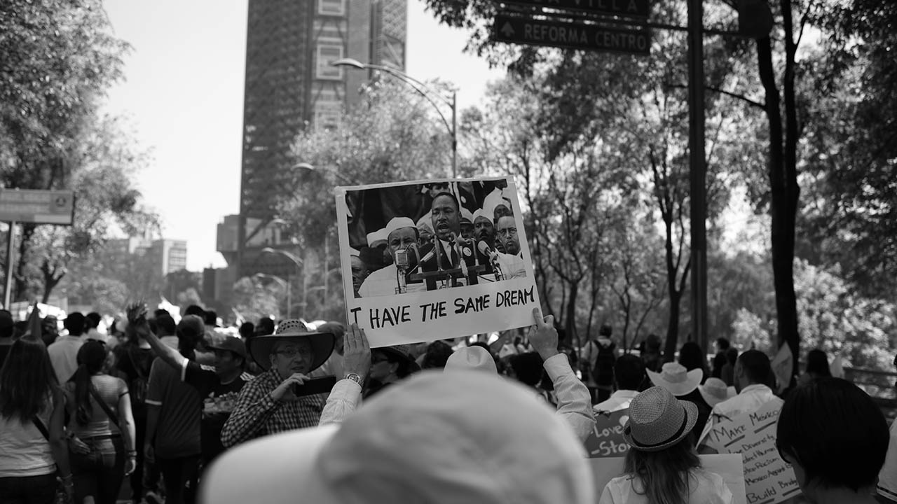 People marching hold up a sign with Dr. Martin Luther King, Jr. on it.
