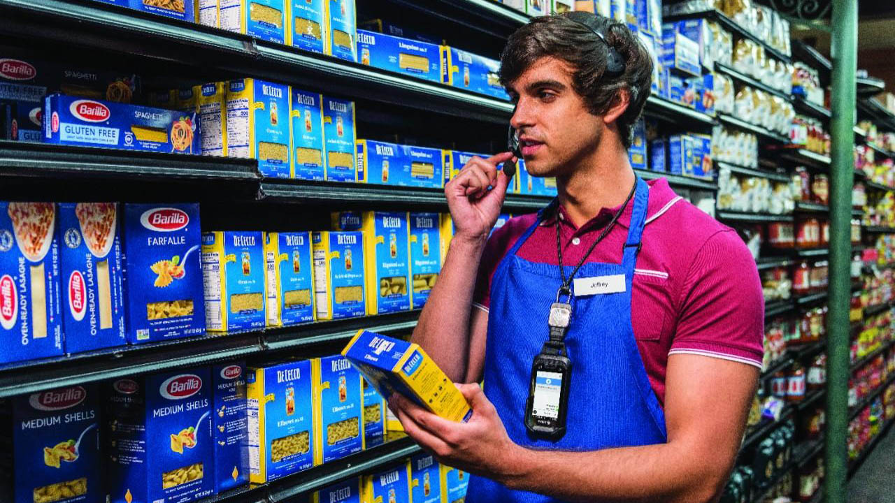 A grocery store worker uses a Zebra mobile computer and Workforce Connect PTT to retreive an online order item for a customer