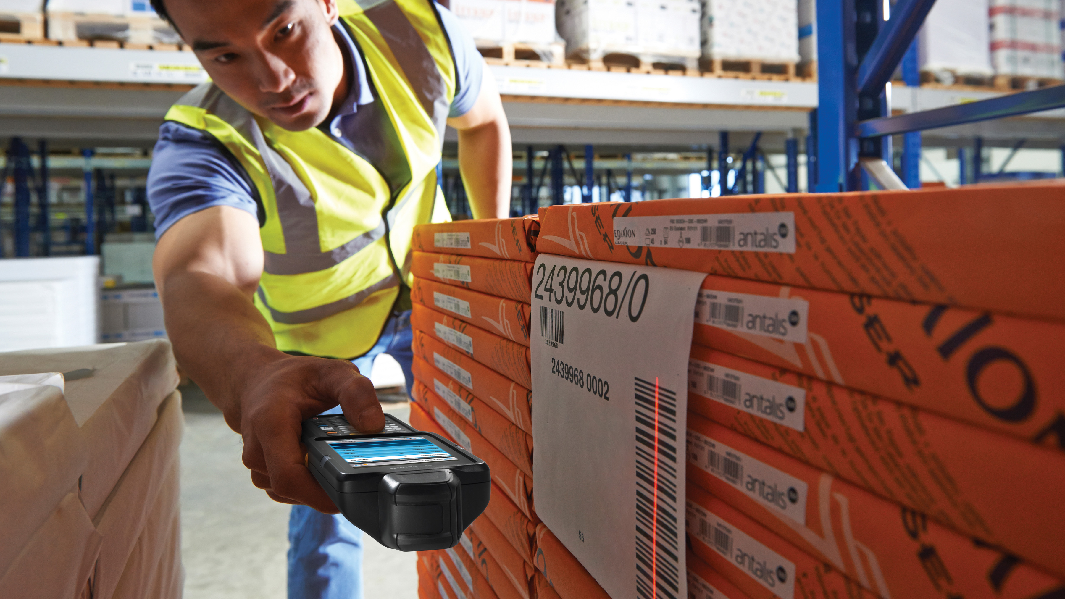 A warehouse worker scans a barcode from a hard to reach place.