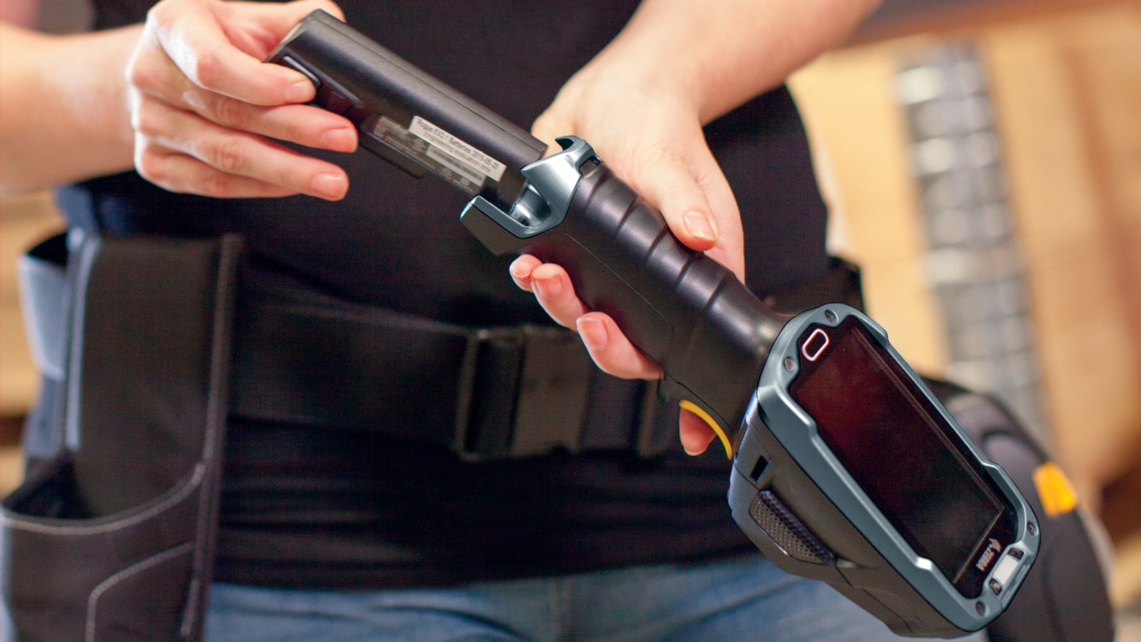 A person is inserting a battery into a Zebra device.