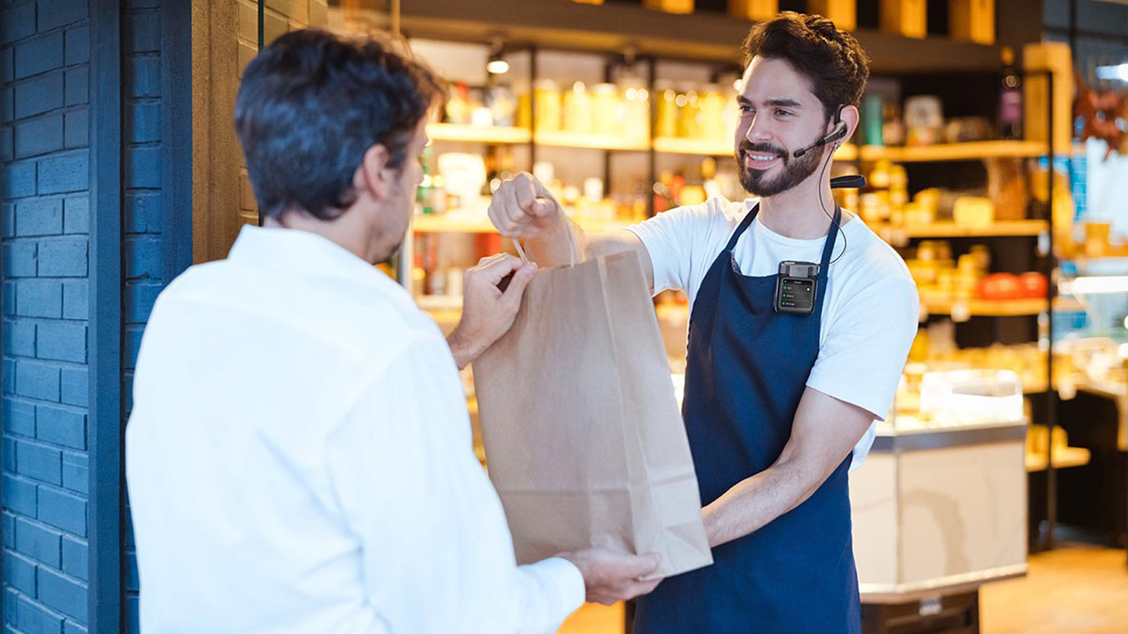 In a modern retail environment, a salesperson uses a headset to efficiently deliver a package to a customer completing a store pickup..