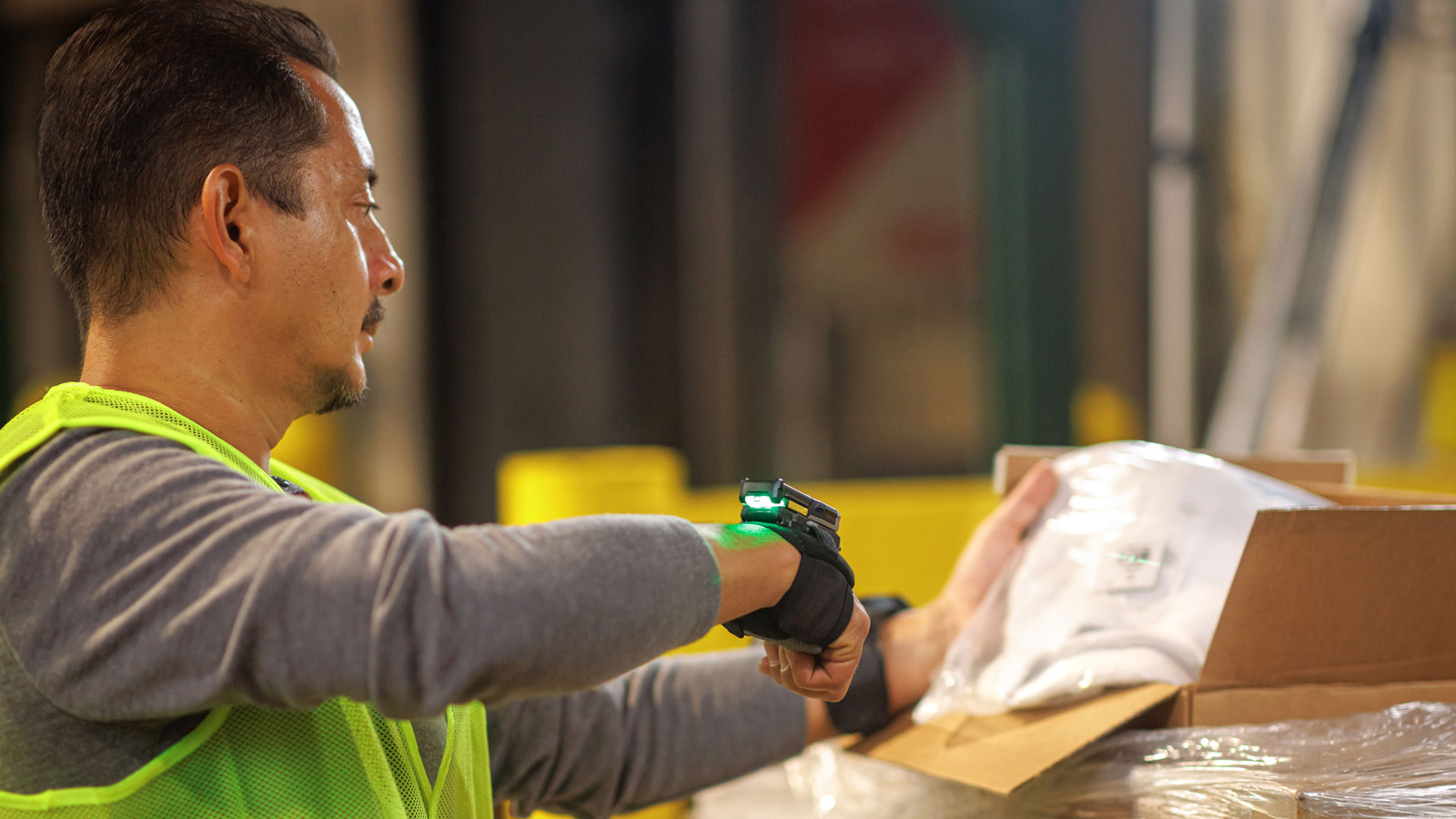 A worker involved in inbound logistics scans a package label, ensuring accurate data entry for received goods.