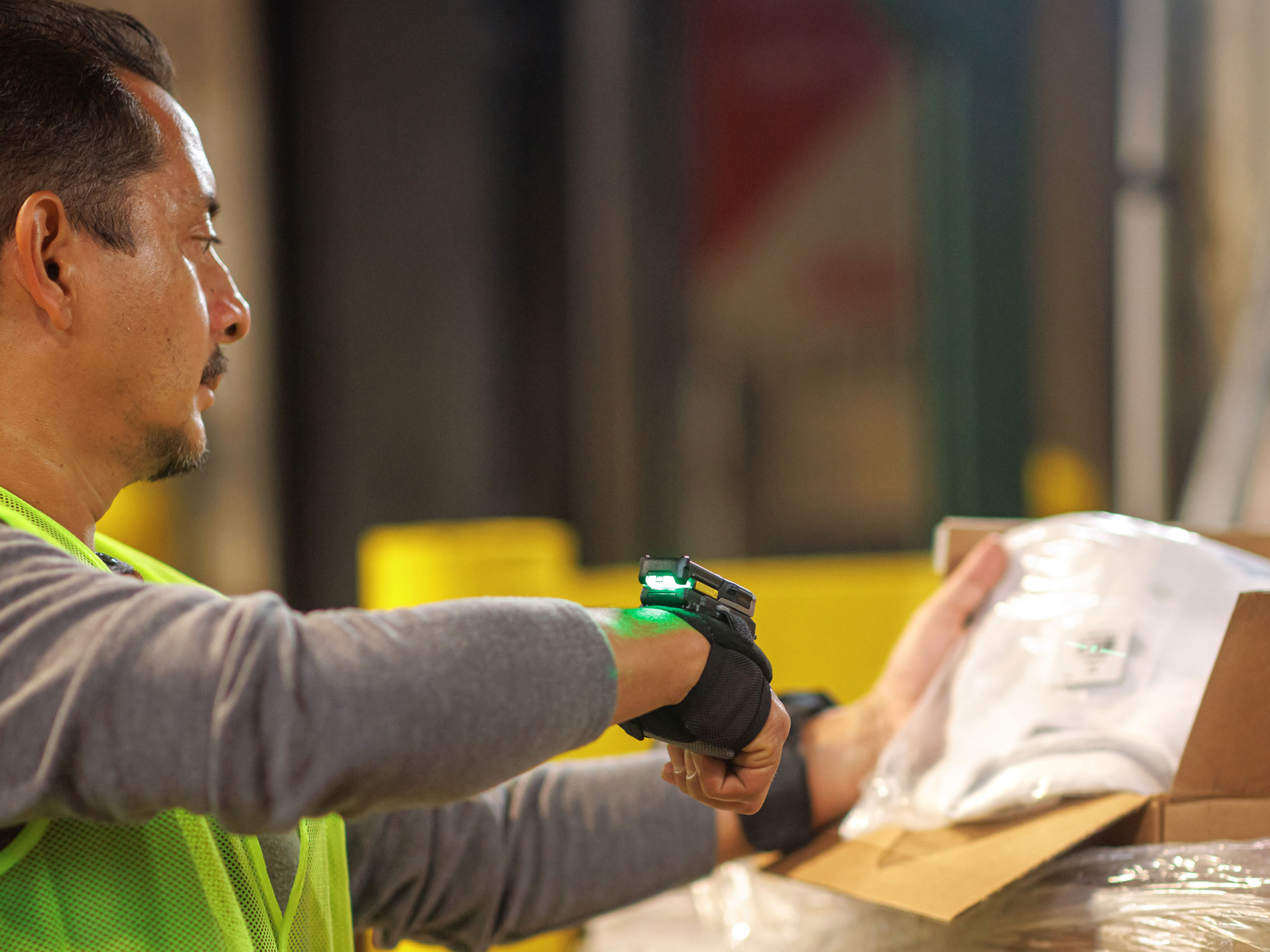 A worker involved in inbound logistics scans a package label, ensuring accurate data entry for received goods.