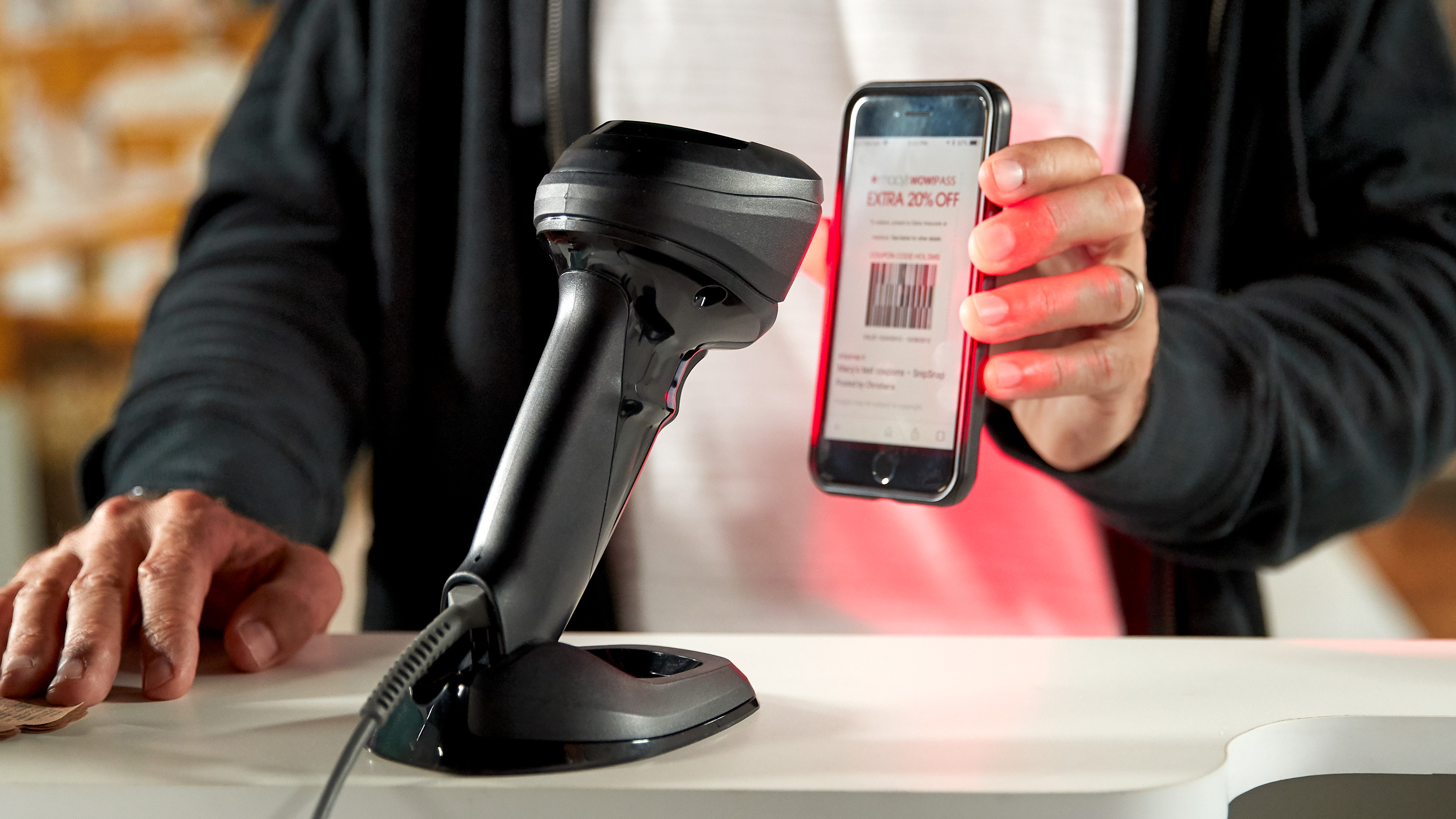 A Zebra scanner scanning a barcode on a mobile device.