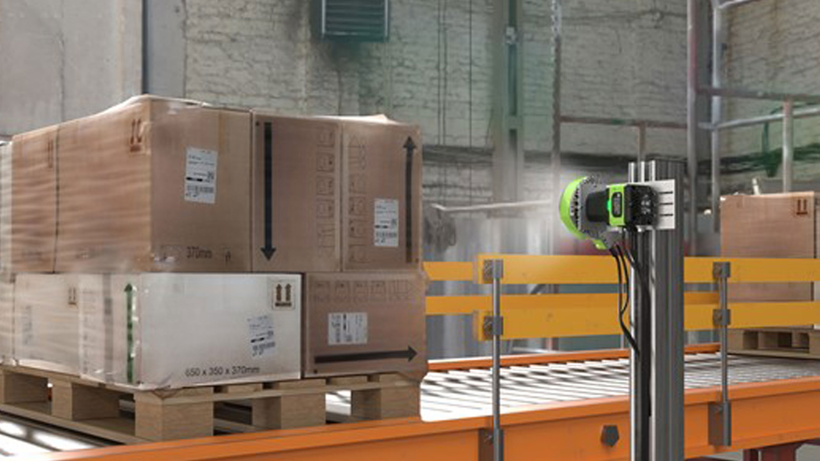 A conveyor system in a warehouse transports pallets of boxed goods, utilizing AI-powered track-and-trace solutions with machine vision technology to scan and read labels on the boxes efficiently.