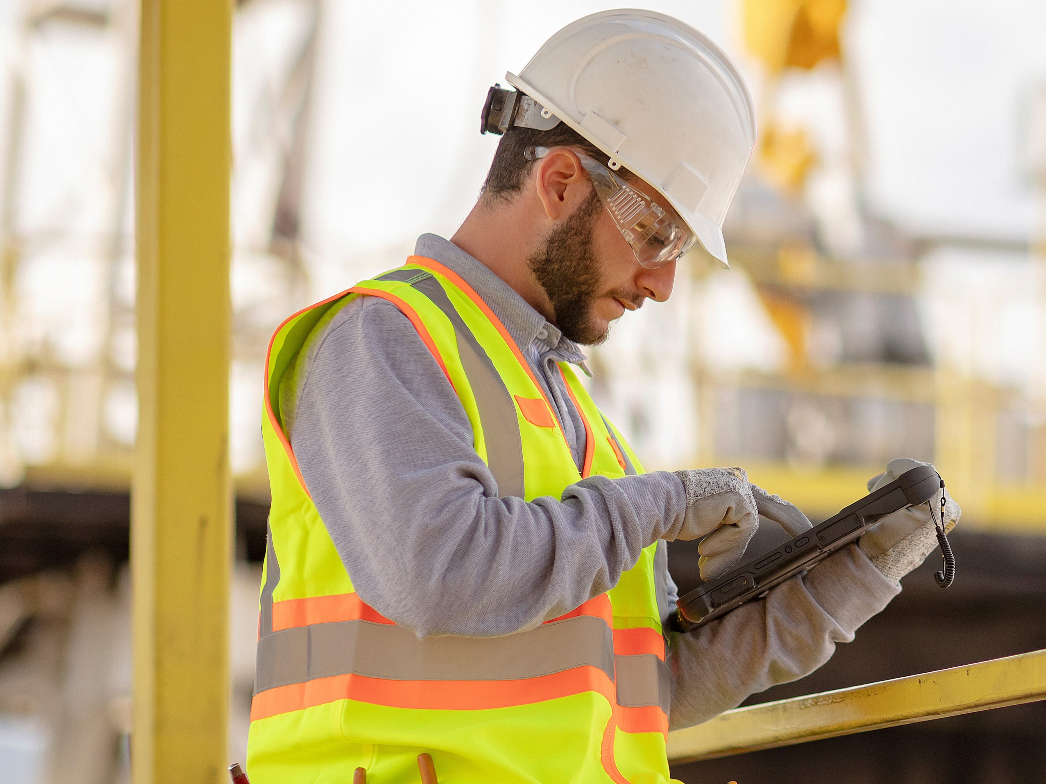 Utilities worker with white hard hat using a zebra tablet