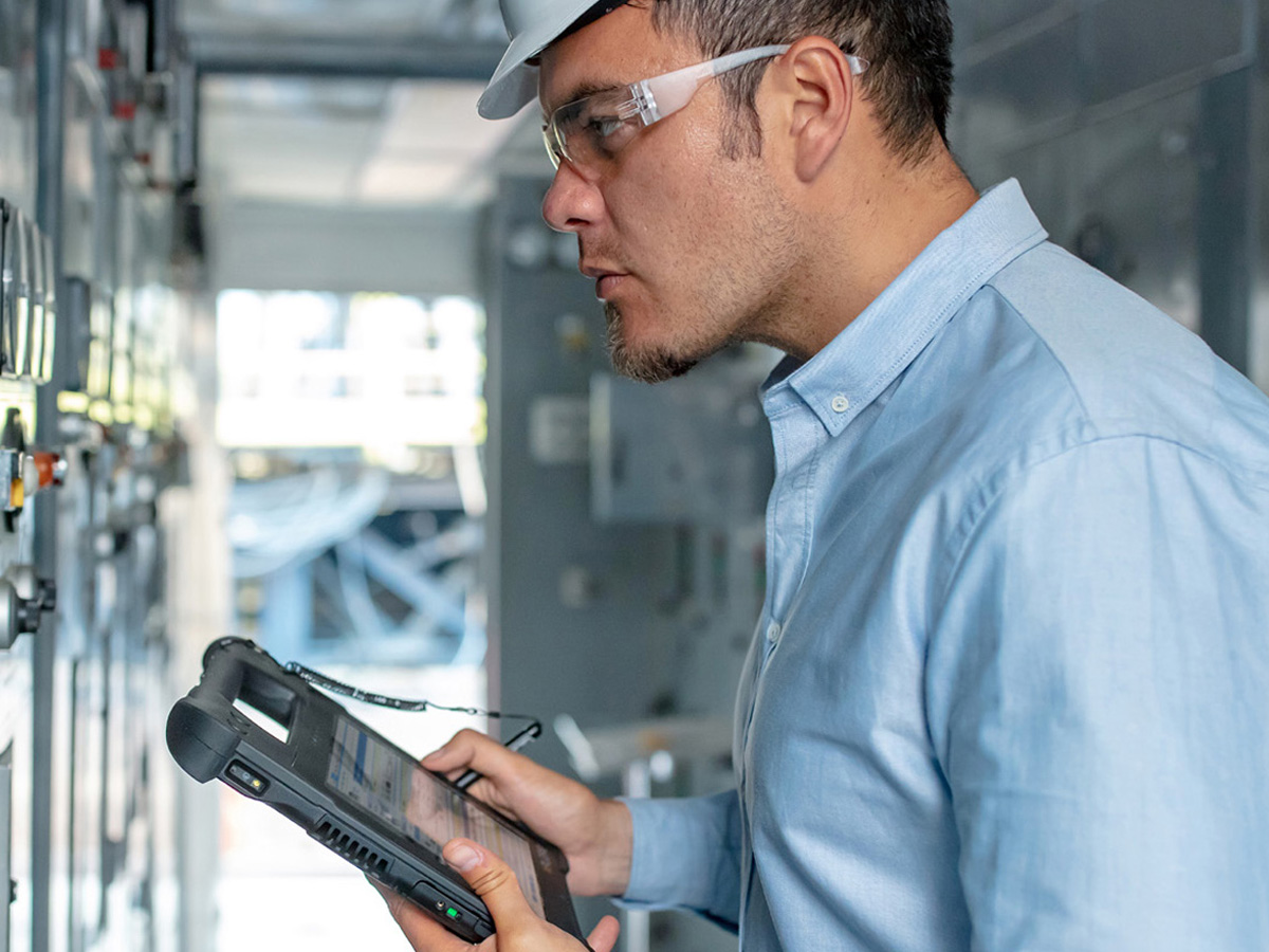 Worker holding a Zebra Tablet within a mechanical room