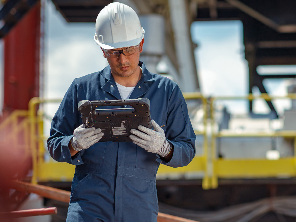 Utilities works with white hard hat on looking at a Zebra Tablet