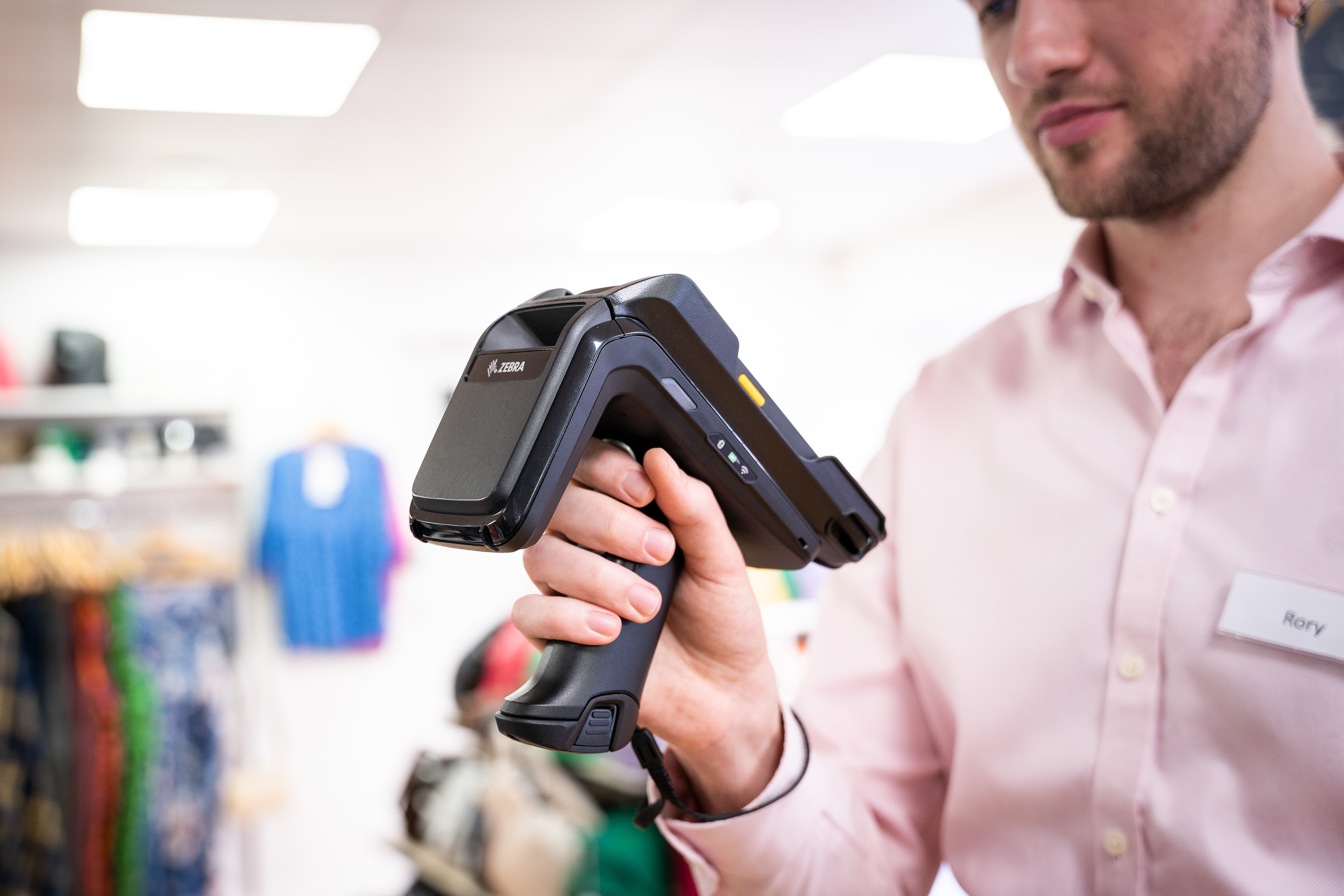 Photography of a store clerk holding a TC22 RFD40