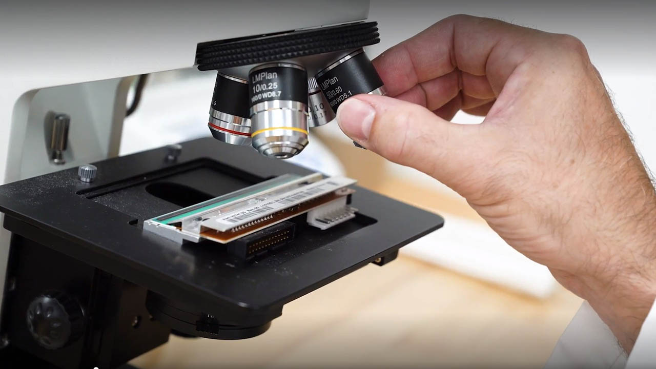 A scientist looks at a barcode under a microscope at the Zebra Supplies and Sensors R&D Innovation Lab